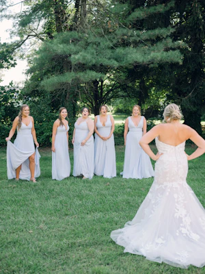 Bride Wearing Lace Mermaid Wedding Gown Called Hattie By Rebecca Ingram Showing Bridesmaids Her Dress