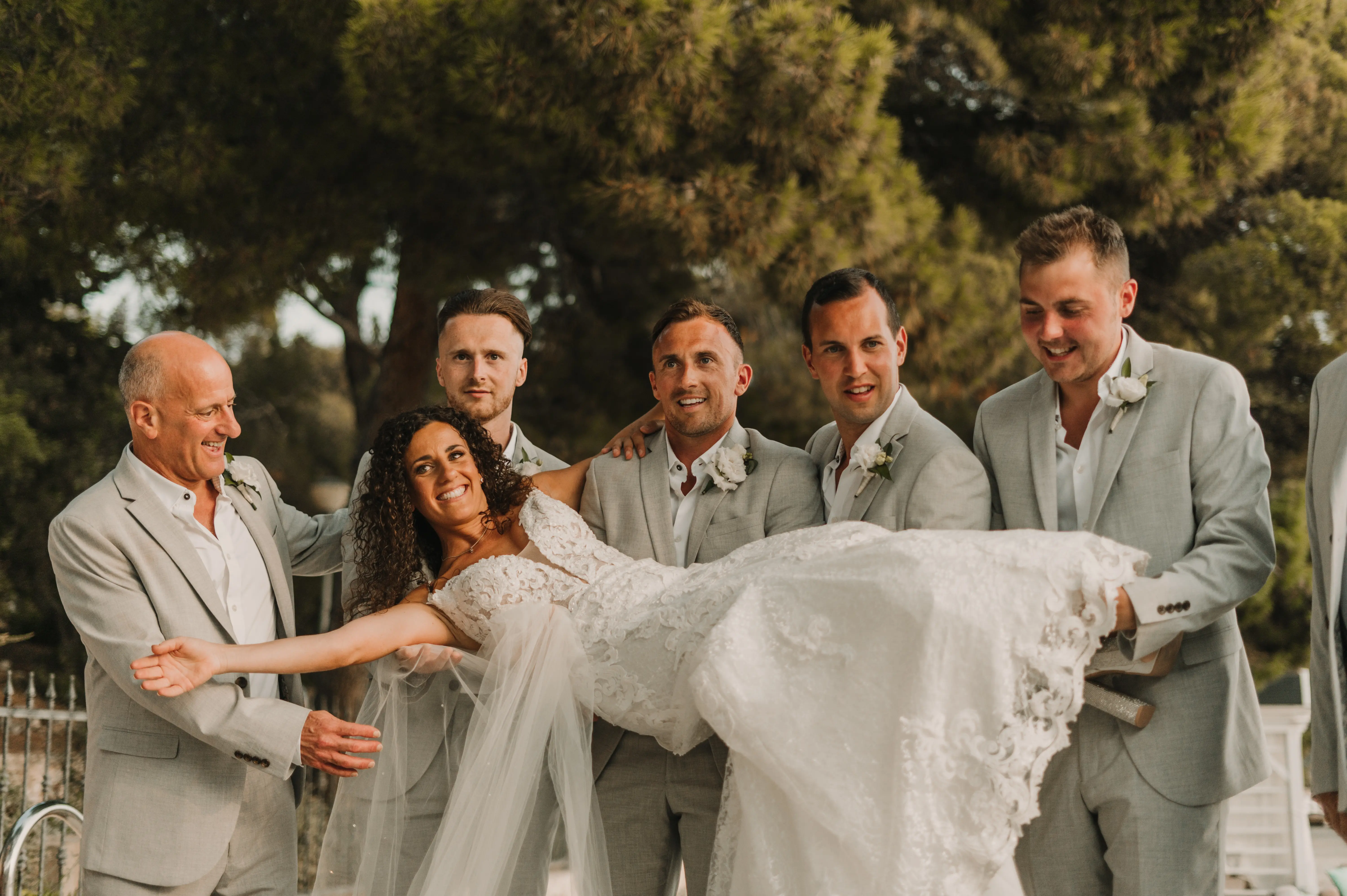 Bride with groomsmen wearing flattering lace A-line wedding dress