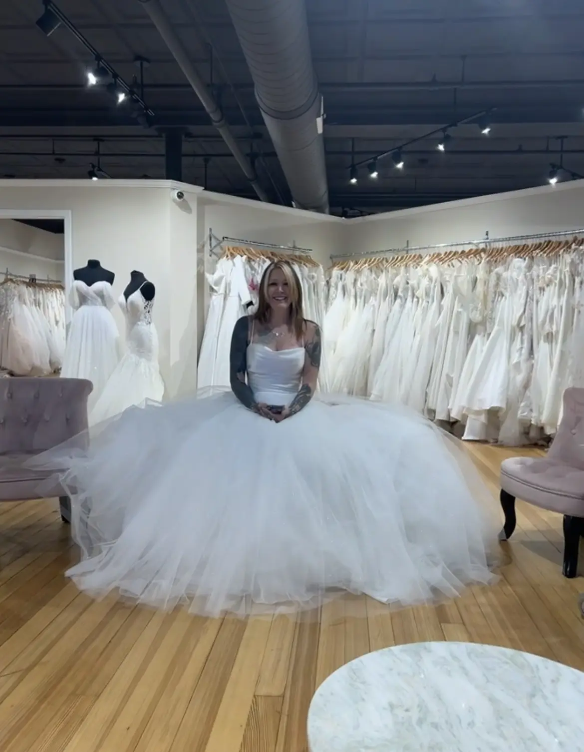 Bride-to-be Trying On Modern Square Neck Ball Gown With Simple Tulle Skirt Called Vivien By Rebecca Ingram