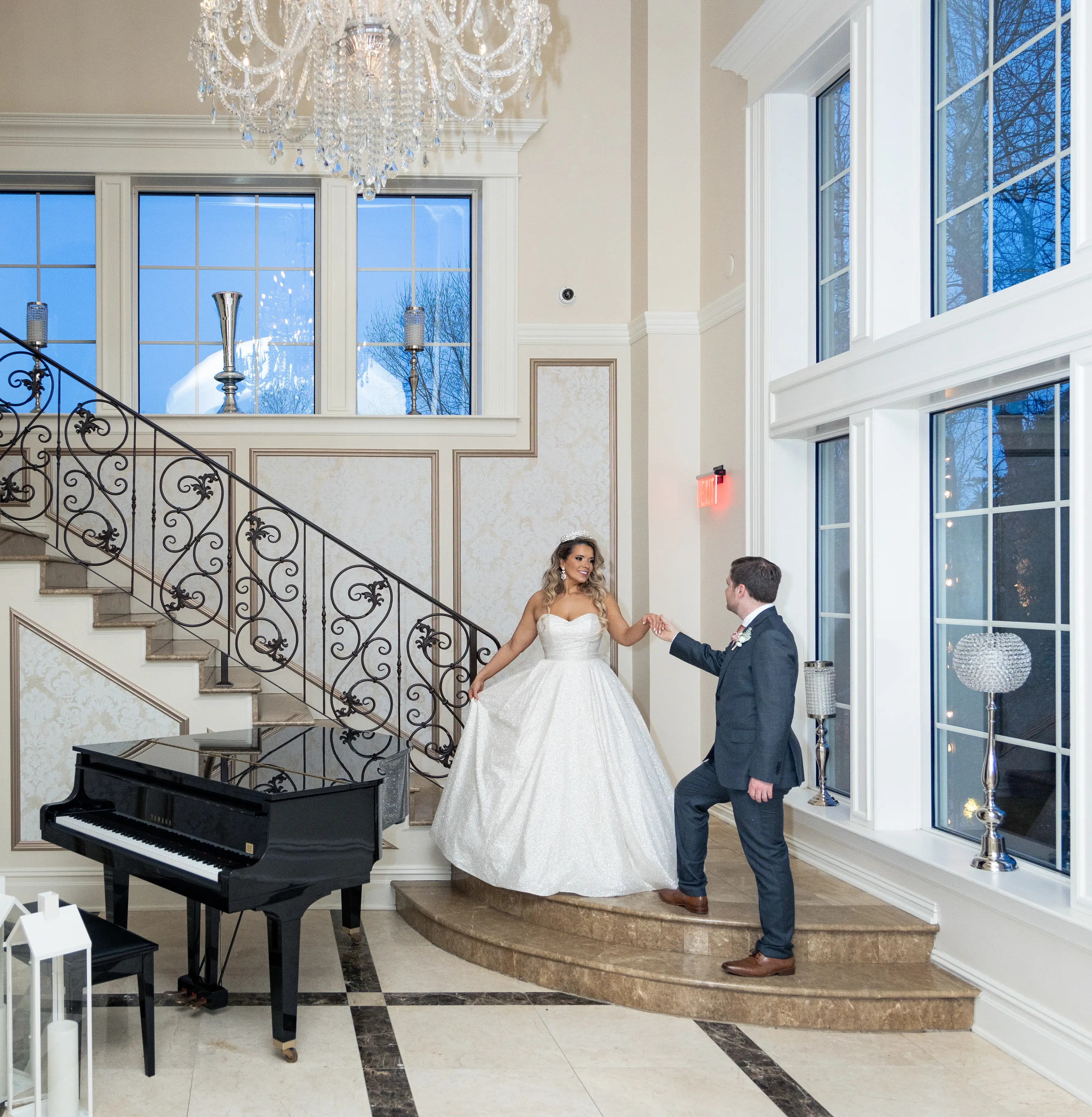 Bride wearing Anniston by Maggie Sottero walking down the stairs with her husband