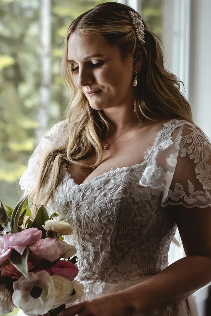 Bride Wearing Lace Aline Wedding Dress Called Harlem By Maggie Sottero Looking At Her Bouquet