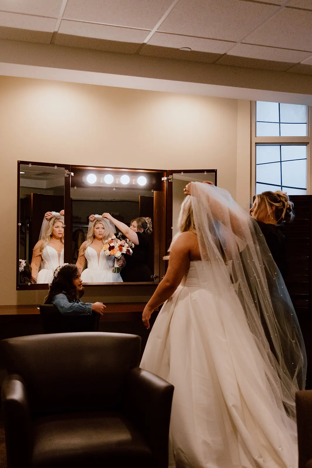 Bride wearing Derrick by Maggie Sottero getting ready in the mirror