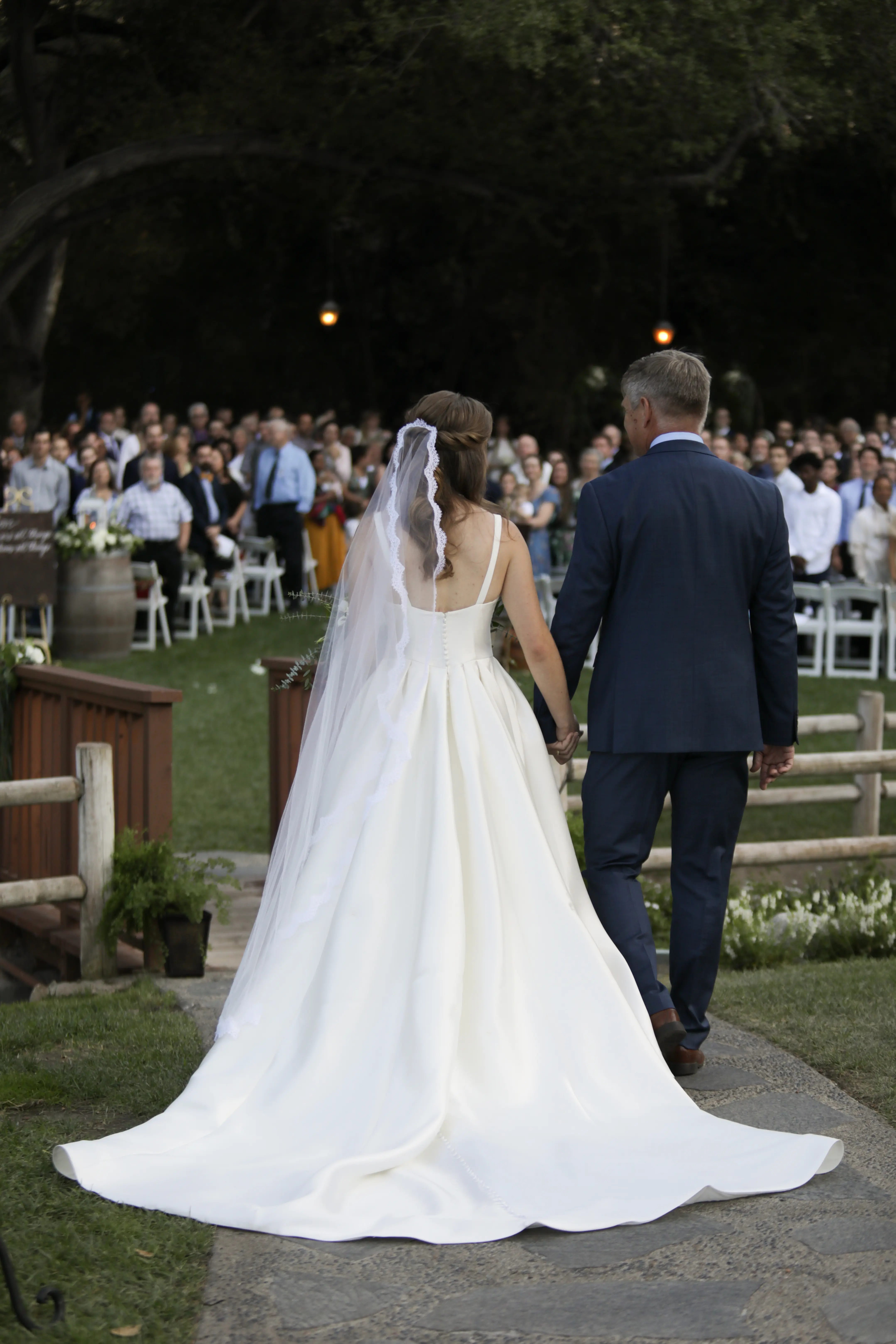 Bride walking with her father while wearing Simple Ballgown Wedding Dress called Selena by Maggie Sottero