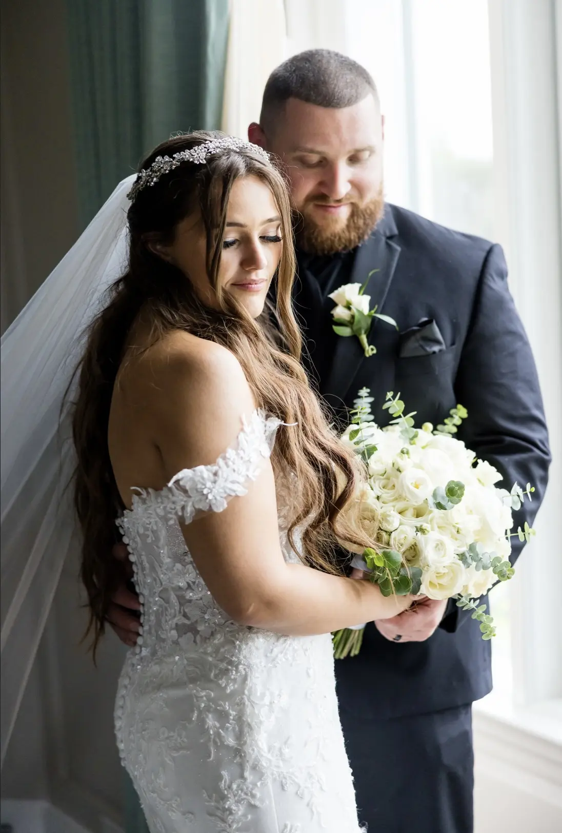 Bride wearing Lennon wedding dress by Maggie Sottero with her husband holding a bouquet