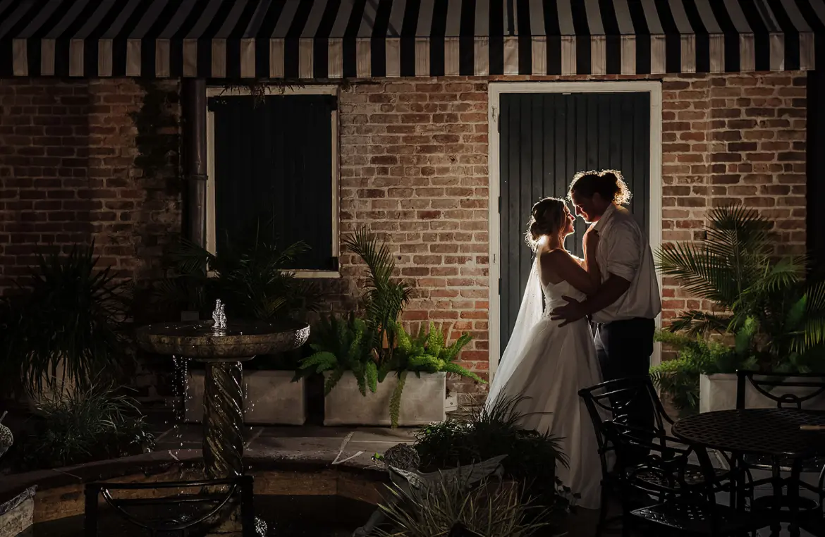 Bride Wearing Modern Princess Wedding Dress Called Aubrielle By Maggie Sottero with Groom Backlit