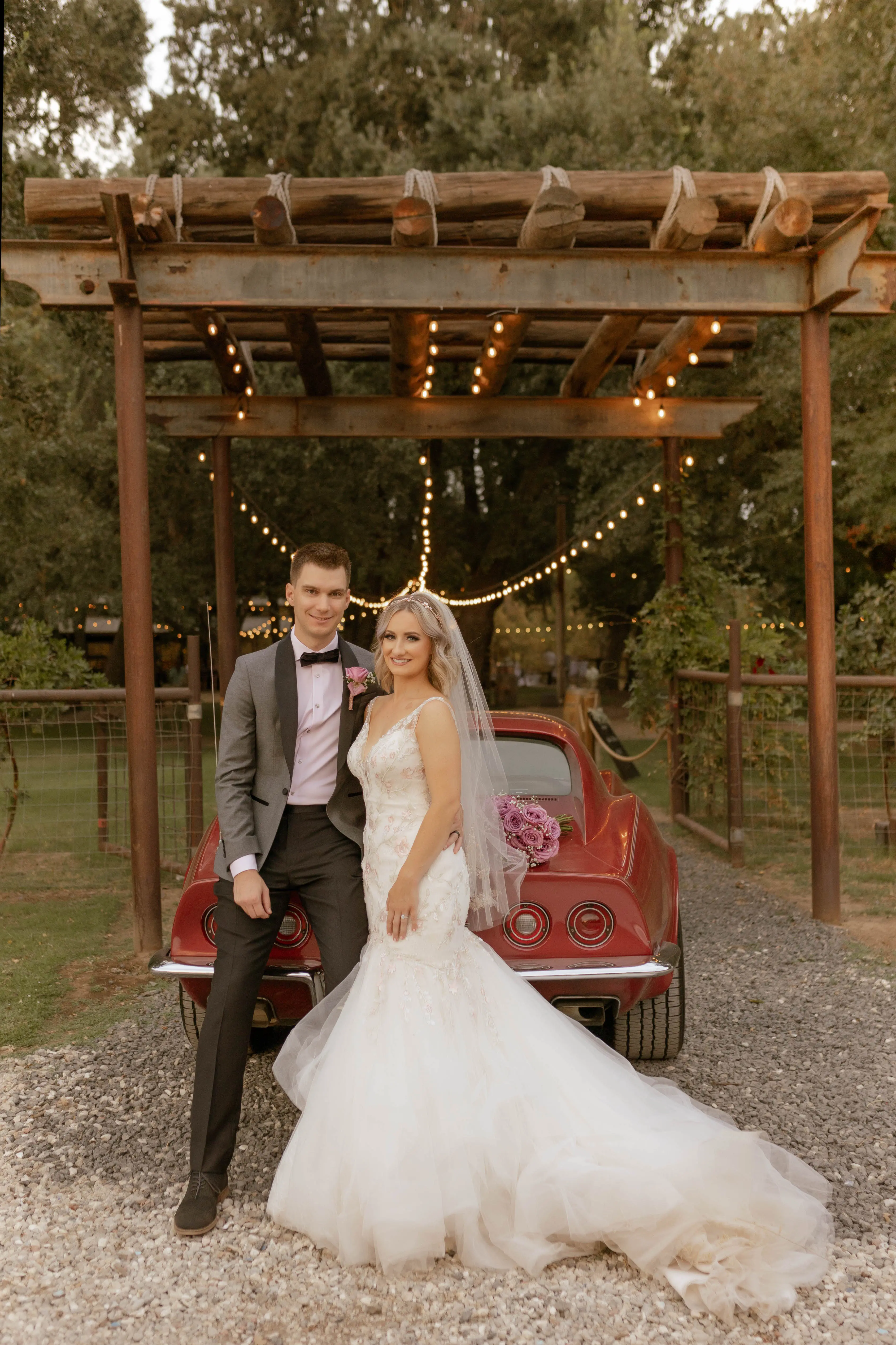 Bride Wearing Pink Lace Mermaid Wedding Dress Called Kenleigh By Sottero And Midgley With Groom Next To Vintage Car