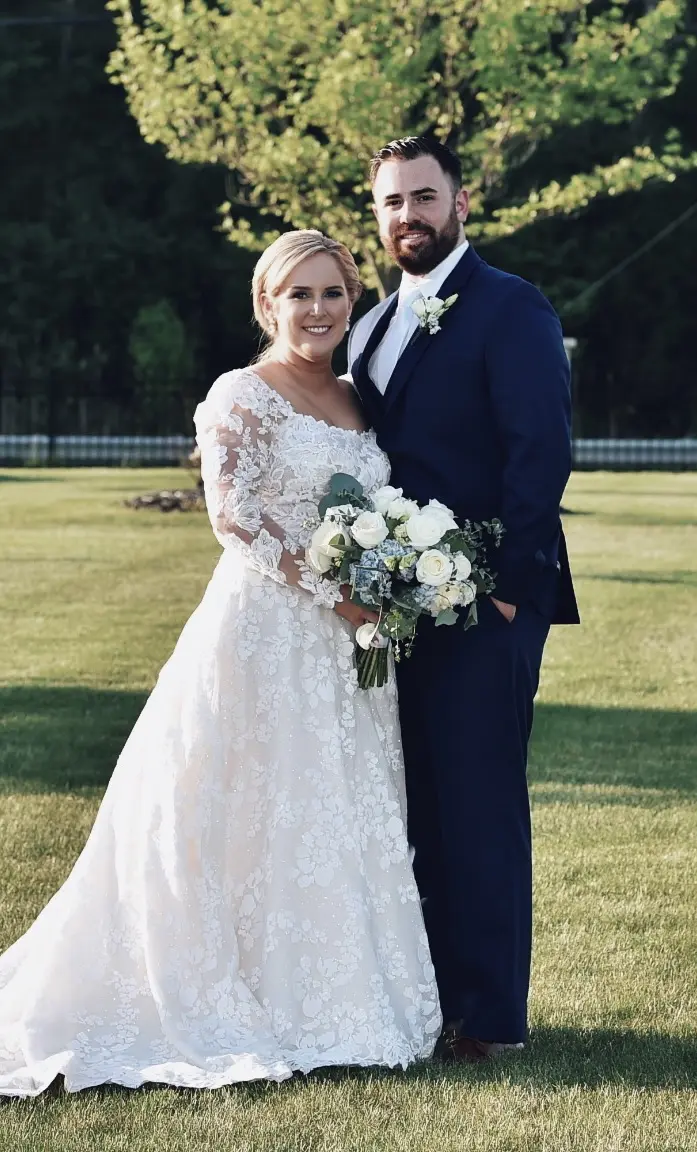 Bride Wearing Long Sleeve Floral Lace Wedding Dress Called Sawyer By Sottero and Midgley Holding Bouquet