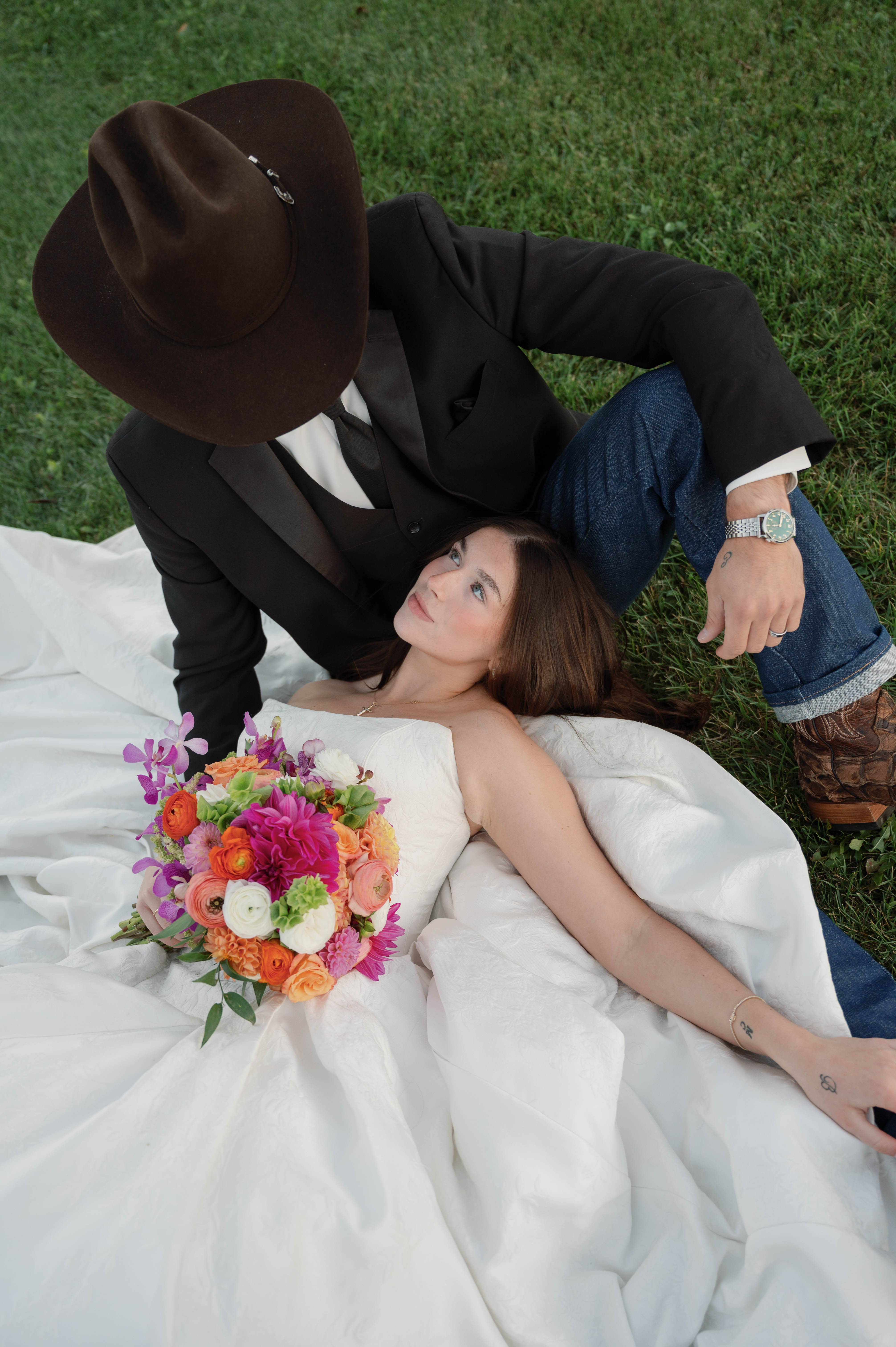 Bride Wearing Jacquard Ballgown Wedding Dress Called Fortune Marie By Maggie Sottero laying next to groom
