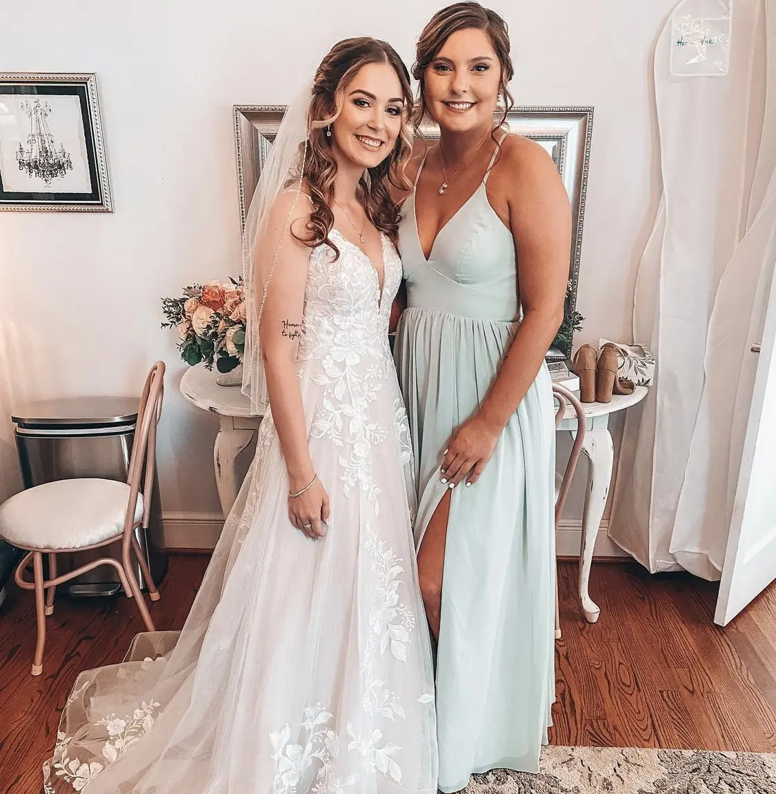 Bride with bridesmaid wearing affordable floral ballgown wedding dress.
