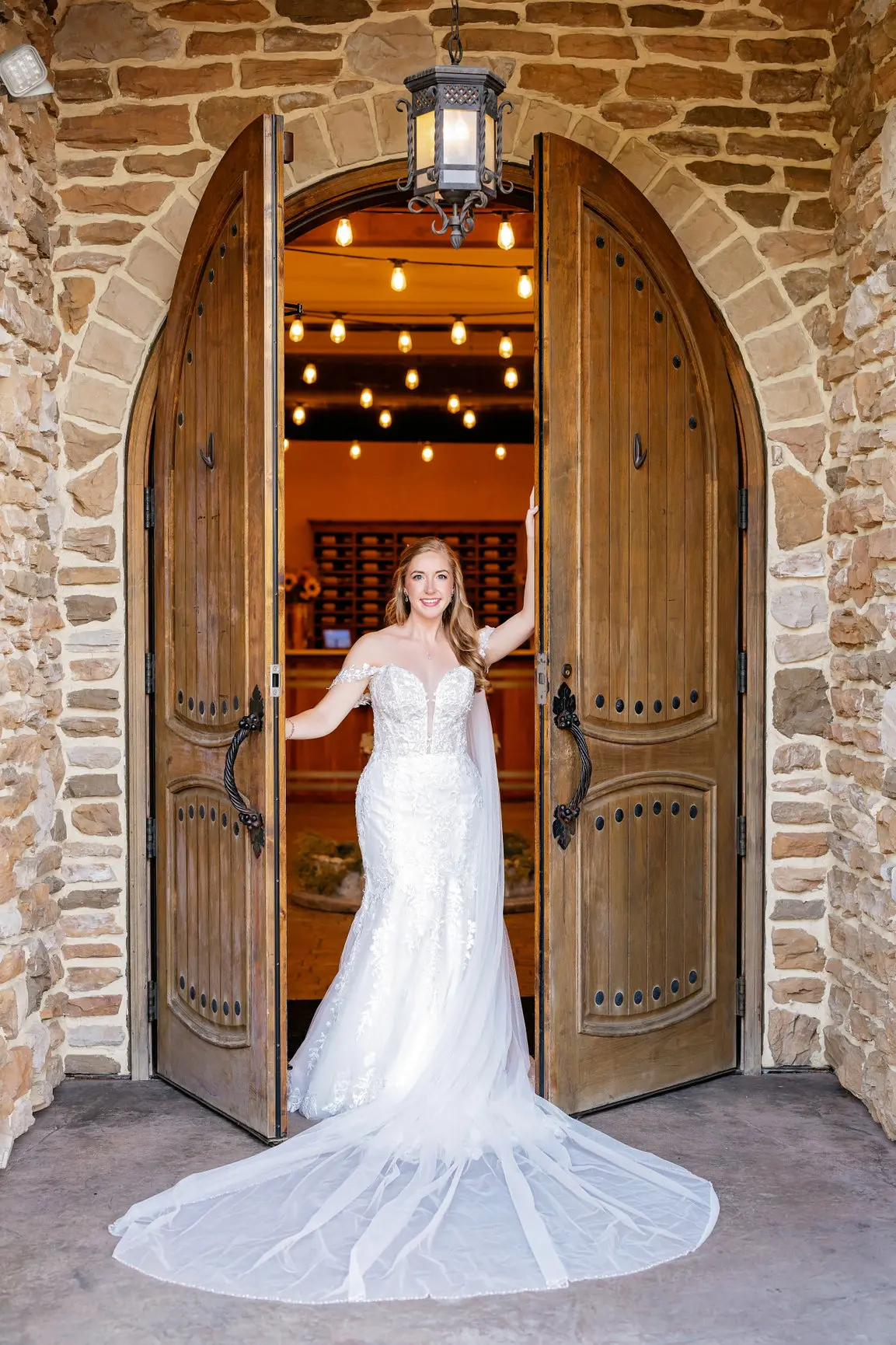 Bride Wearing Lace Wedding Dress Called Lennon By Maggie Sottero Opening A Door To A Wine Cellar