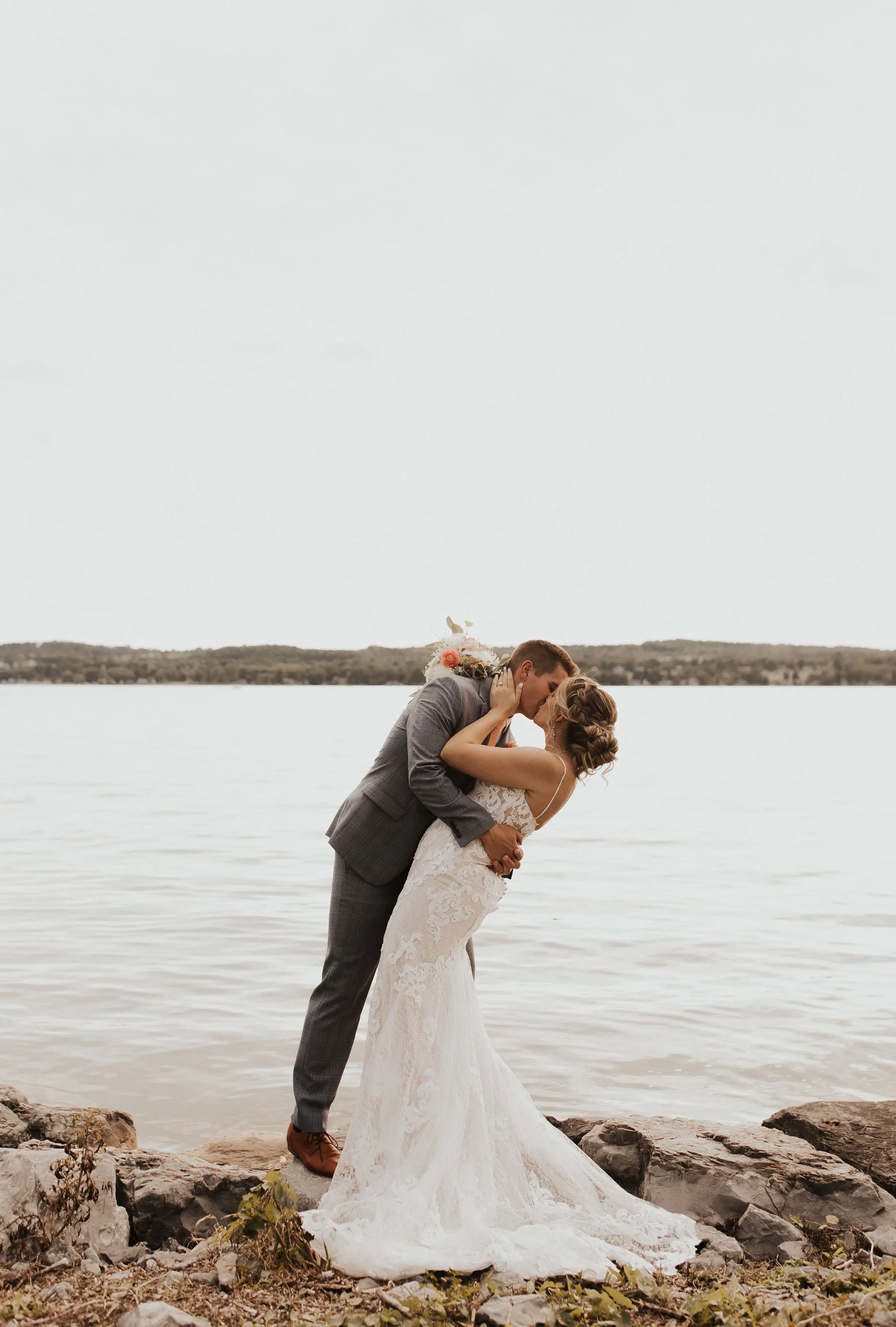 Bride Wearing Lace Sexy Wedding Dress Called Tuscany Lynette By Maggie Sottero With Groom By A Lake