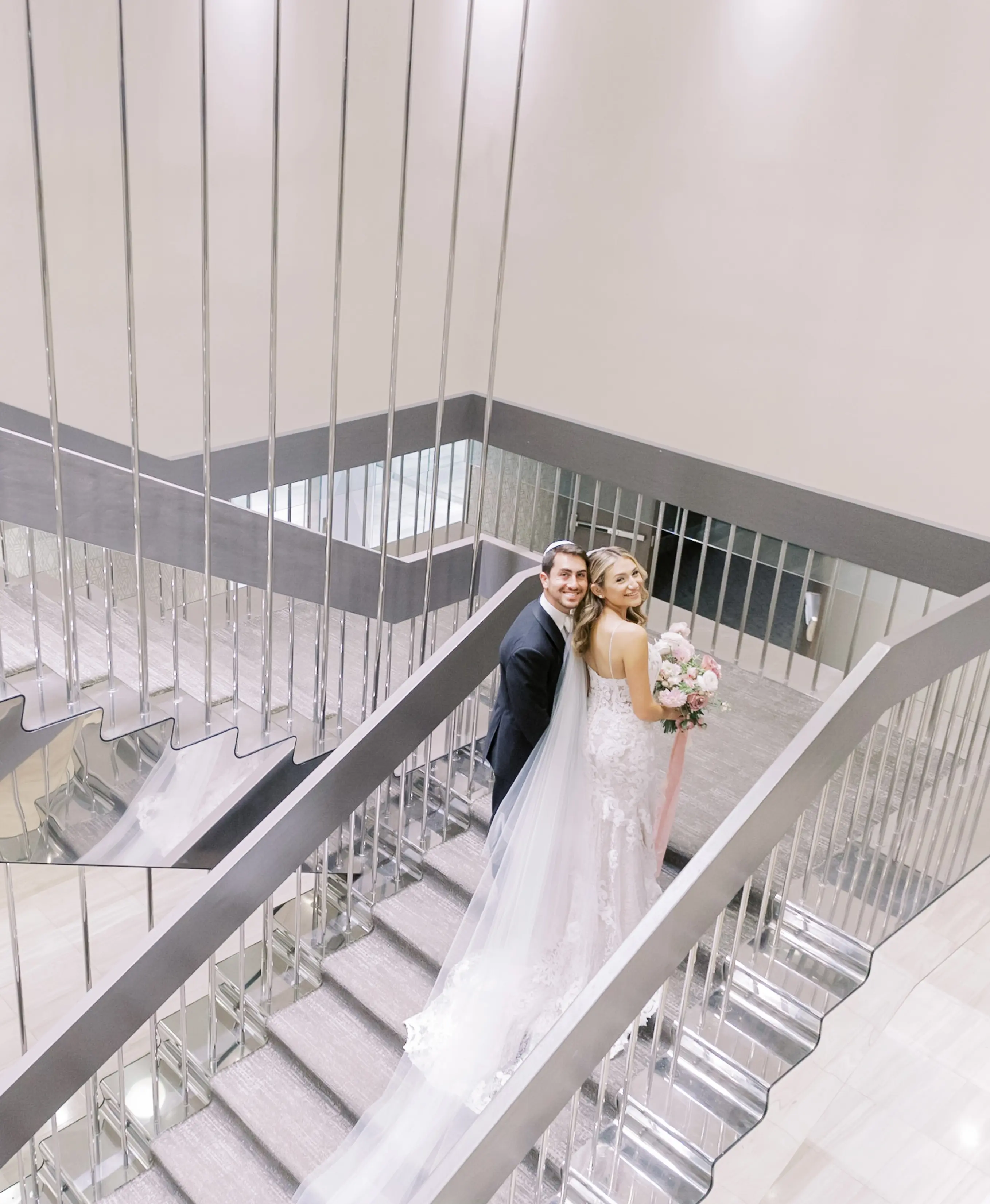 Bride Wearing A Lace Sheath Wedding Gown Named Tuscany Lynette By Maggie Sottero Bride and Groom on Staircase