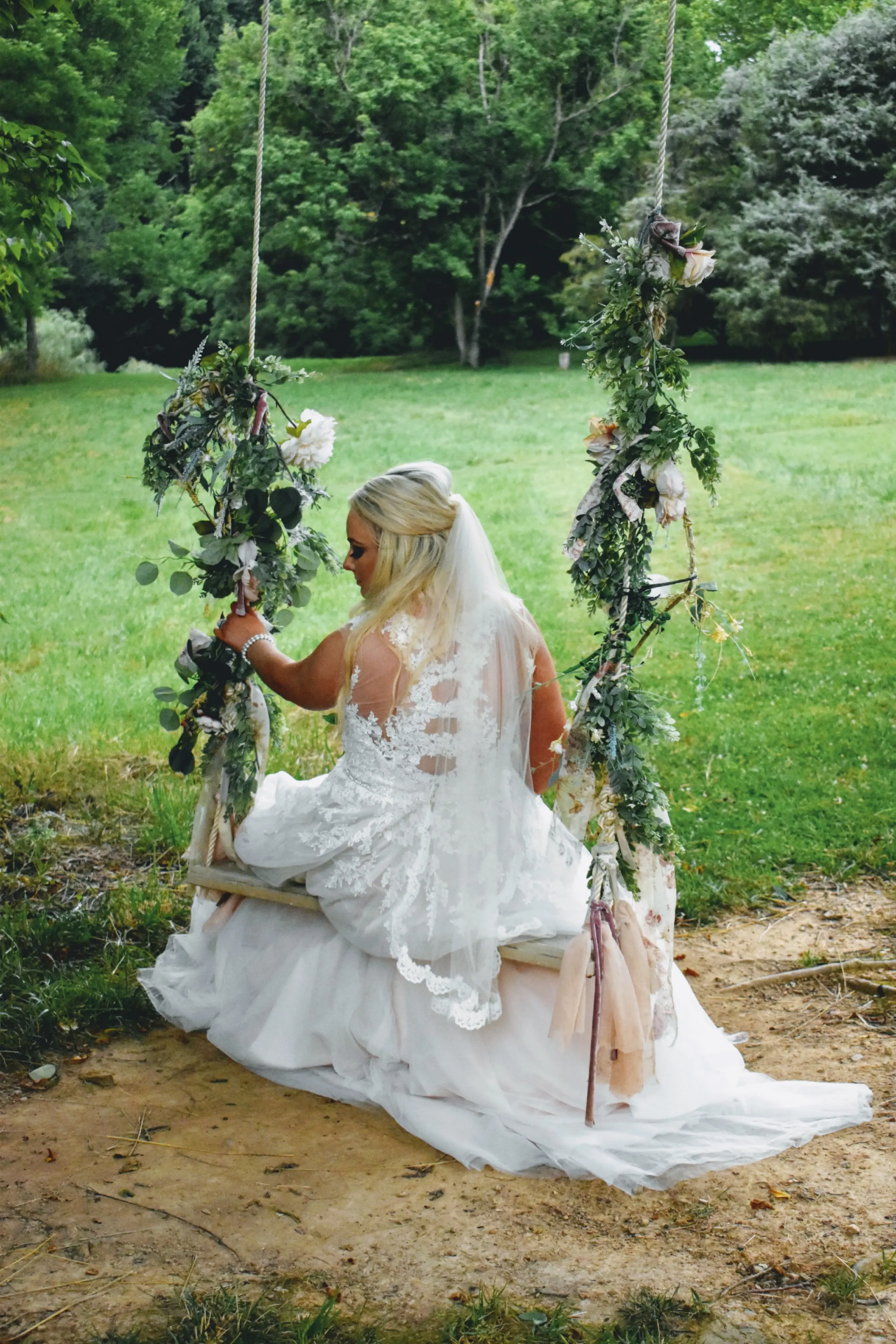 Bride on a Swing Wearing Lace Ballgown Wedding Dress Called Olivia by Rebecca Ingram