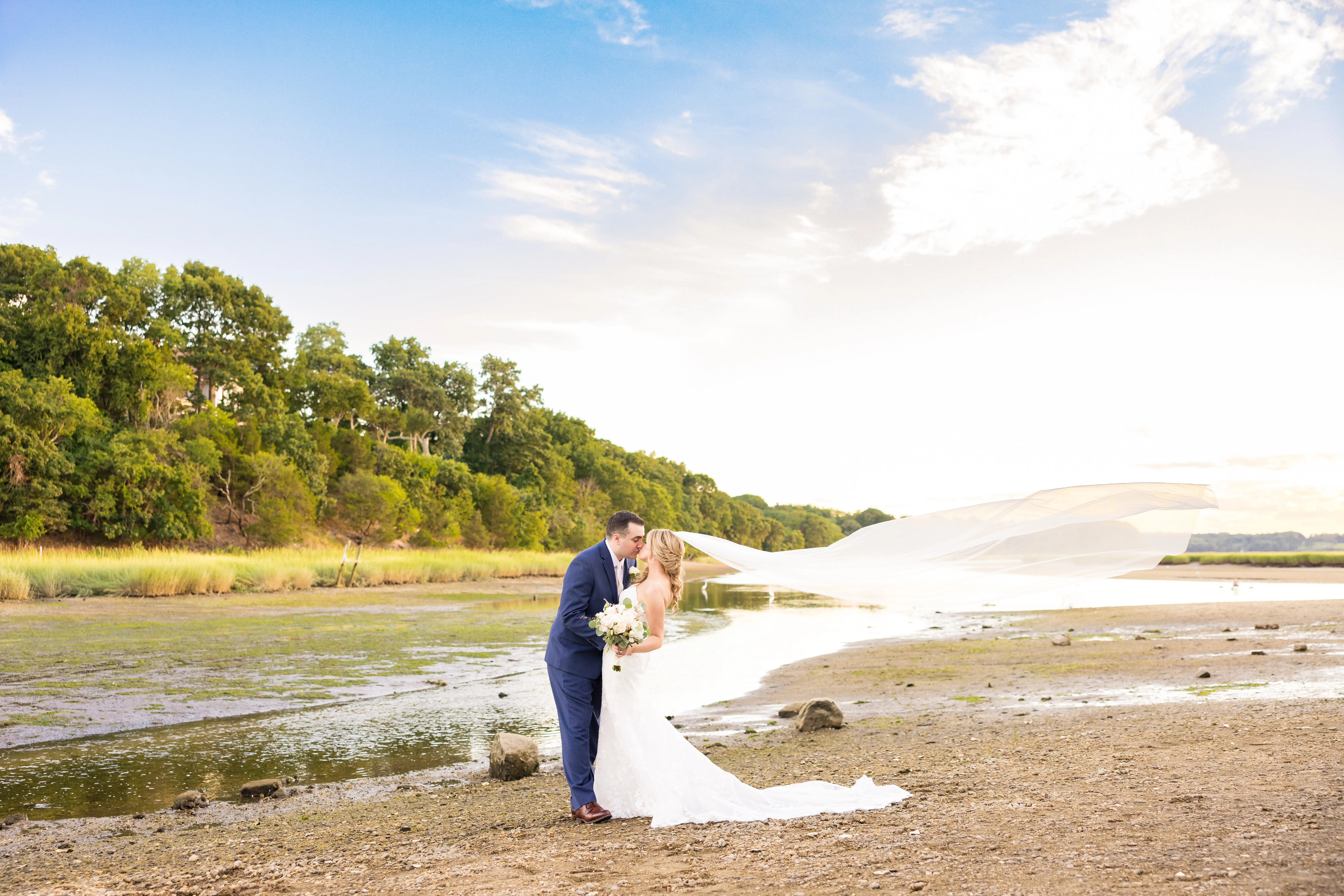 Bride Wearing 3-D Flower Fit-And-Flare Bridal Gown Named Ryker by Sottero and Midgley Bride And Groom Kissing By Pond