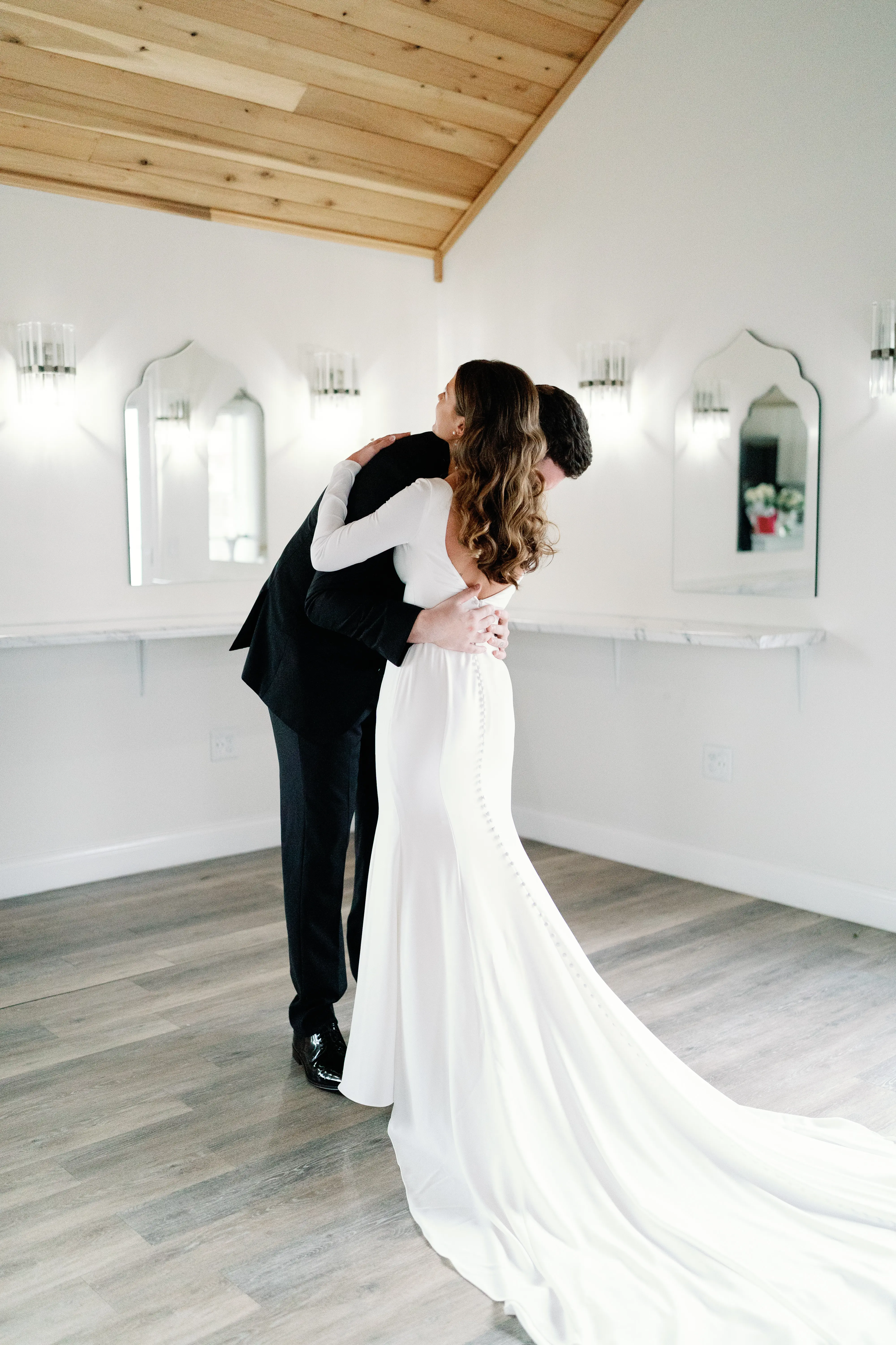 Bride wearing Fernanda wedding dress by Maggie Sottero hugging her husband