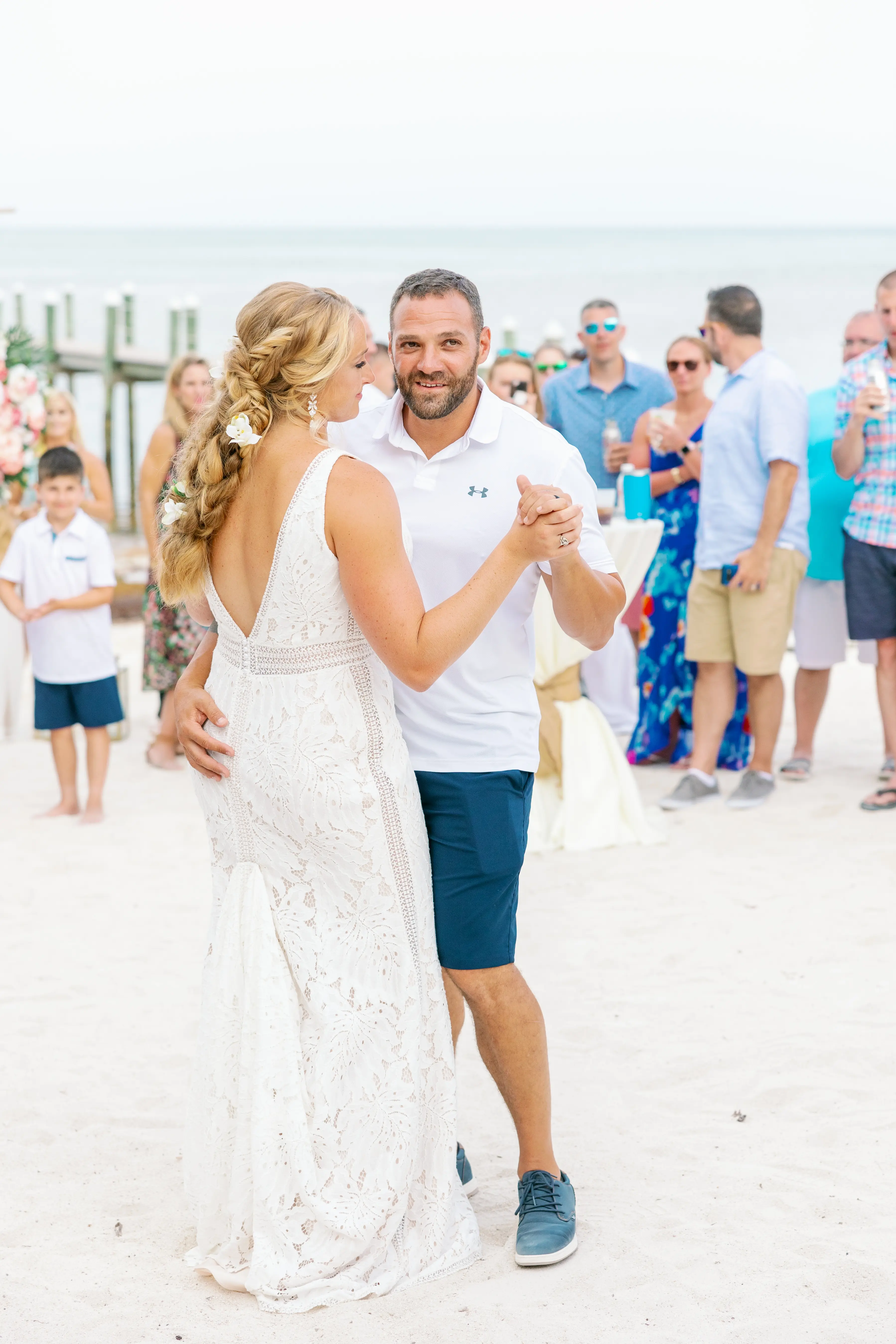 Groom smiling as he has his first dance with his bride wearing wedding dress called Burke.