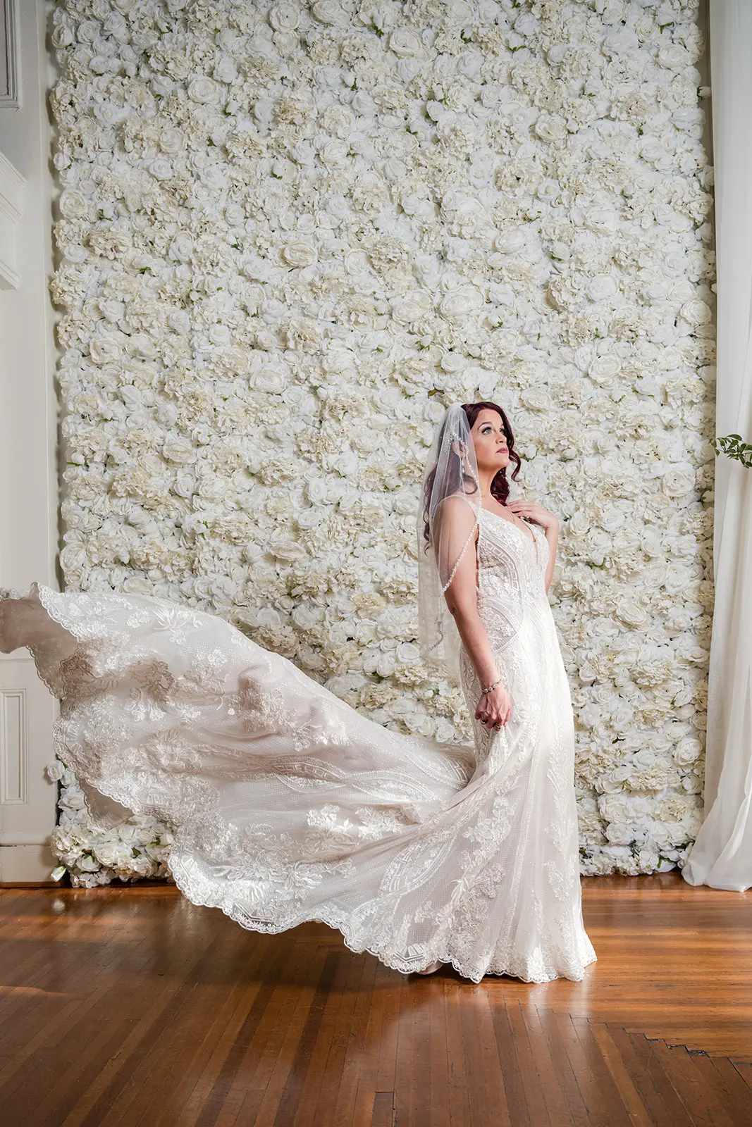 Bride wearing Bailey by Sottero and Midgley in front of a flower wall