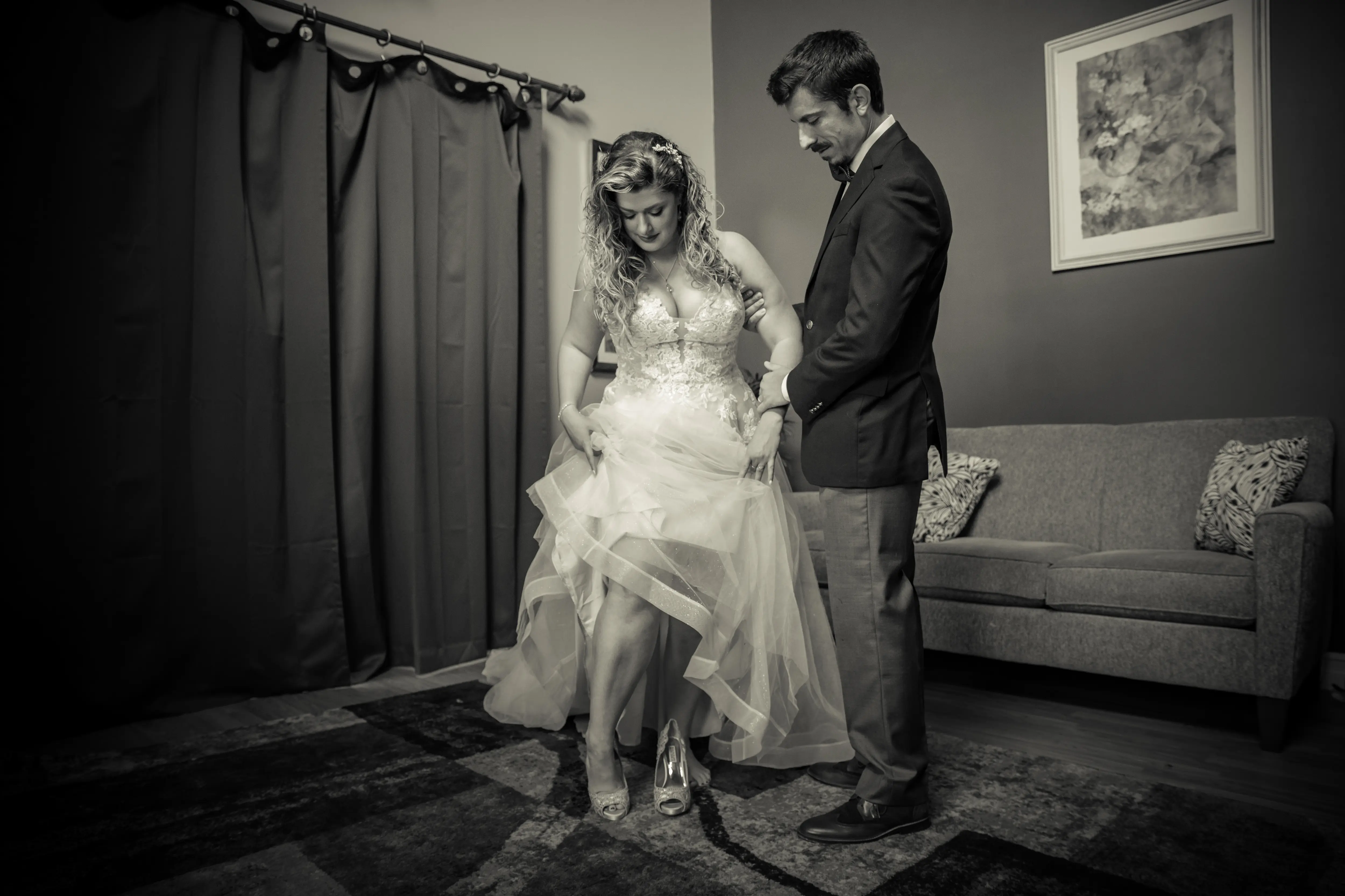 Bride Wearing Boho A-Line Wedding Dress Called Stevie By Maggie Sottero With Groom Putting On Her Shoes