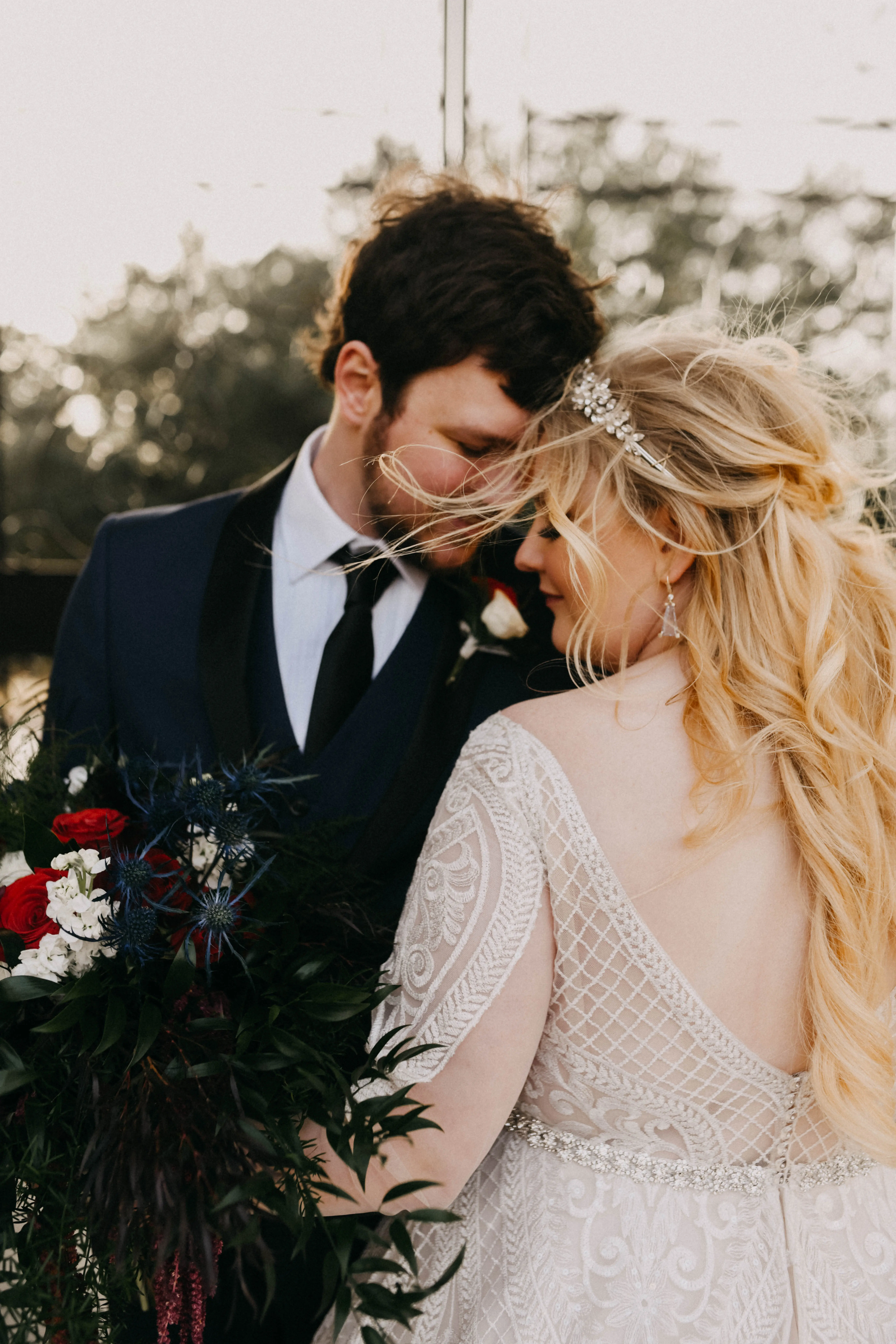 Close up of bride and groom face to face with wind swept hair.