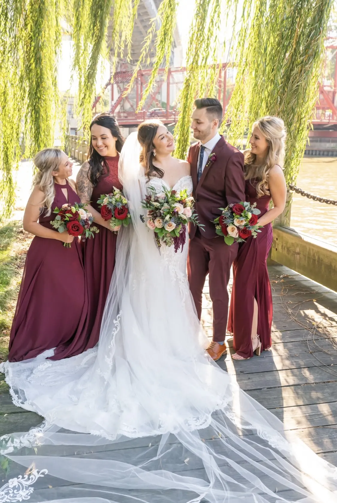Bride with bridesmaids wearing cap sleeve lace mermaid wedding dress.
