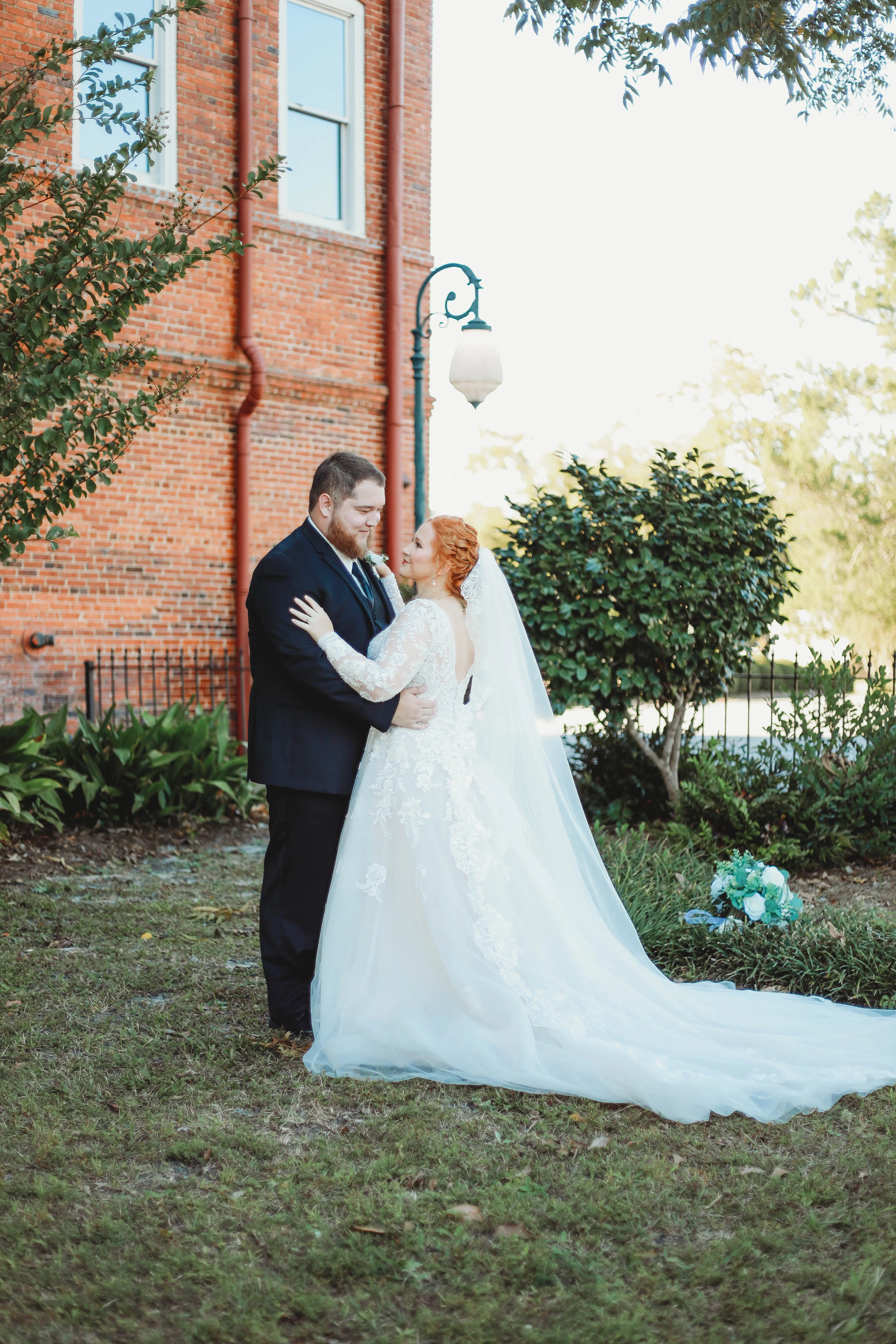 Bride Wearing Lace Long-Sleeve Wedding Gown Called Raphael By Maggie Sottero With Groom