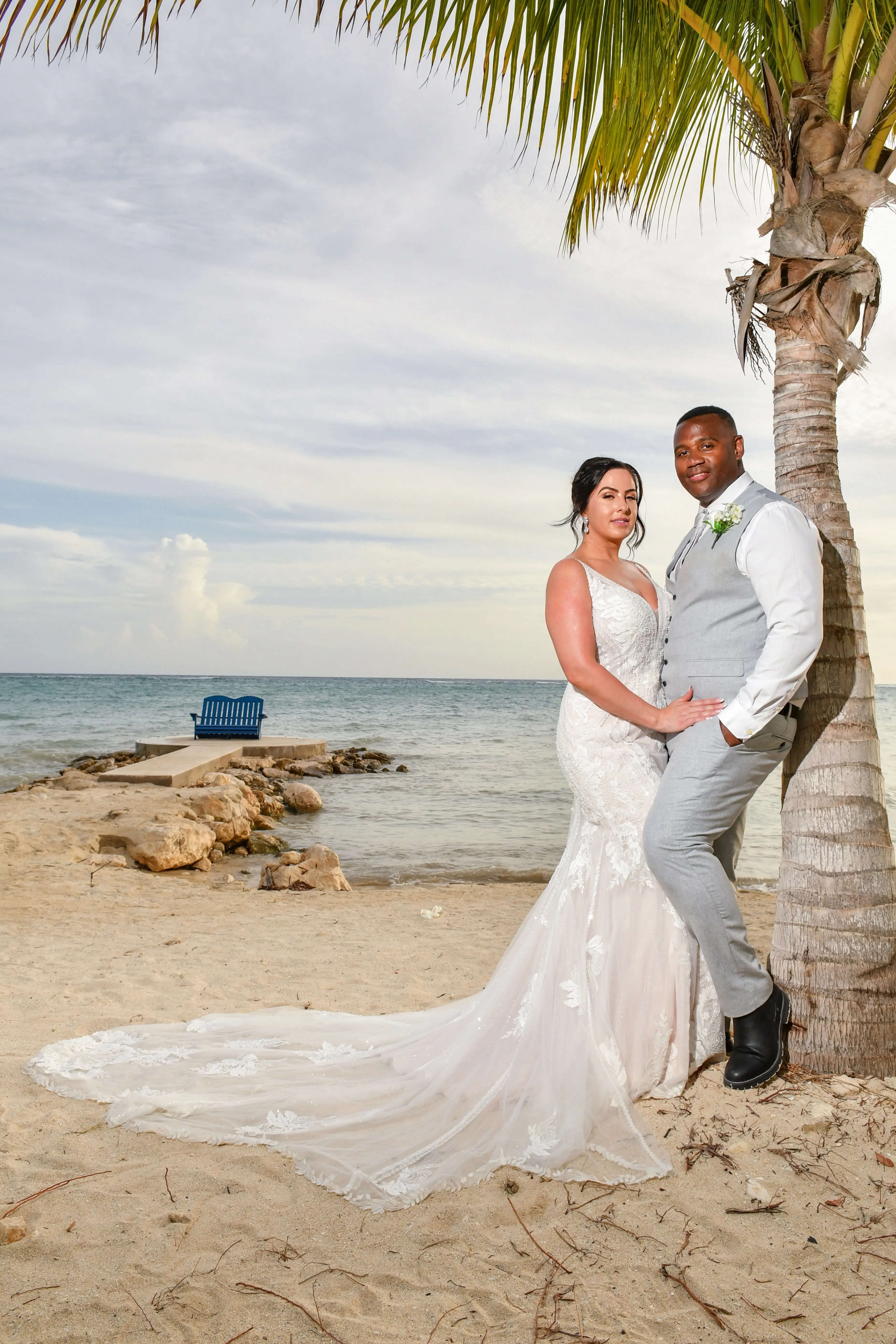 Bride wearing Franklynn by Sottero and Midgley with her husband near a palm tree