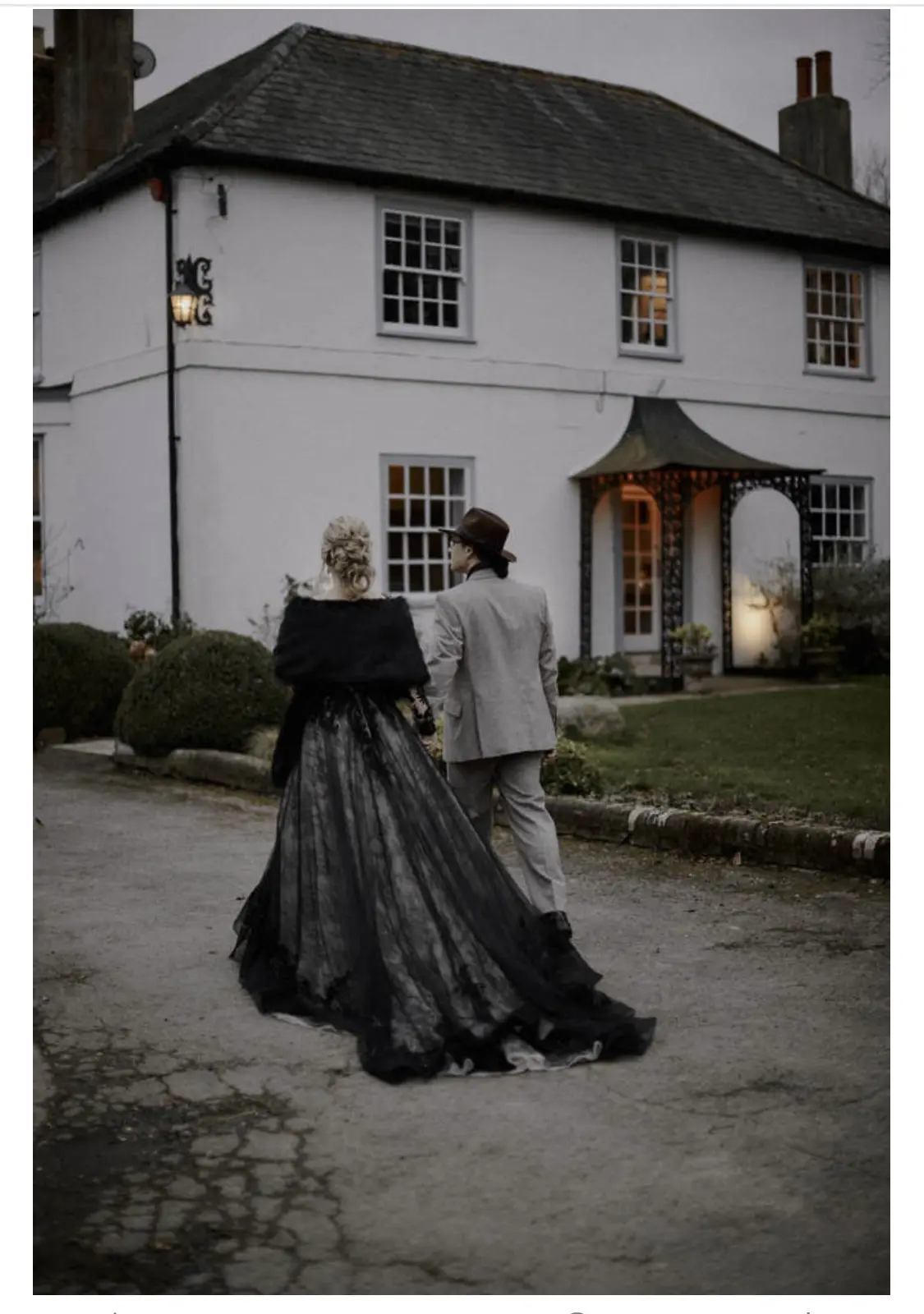 Bride Wearing Black Lace Wedding Gown Called Zander By Sottero and Midgley With Groom By A Gothic Mansion