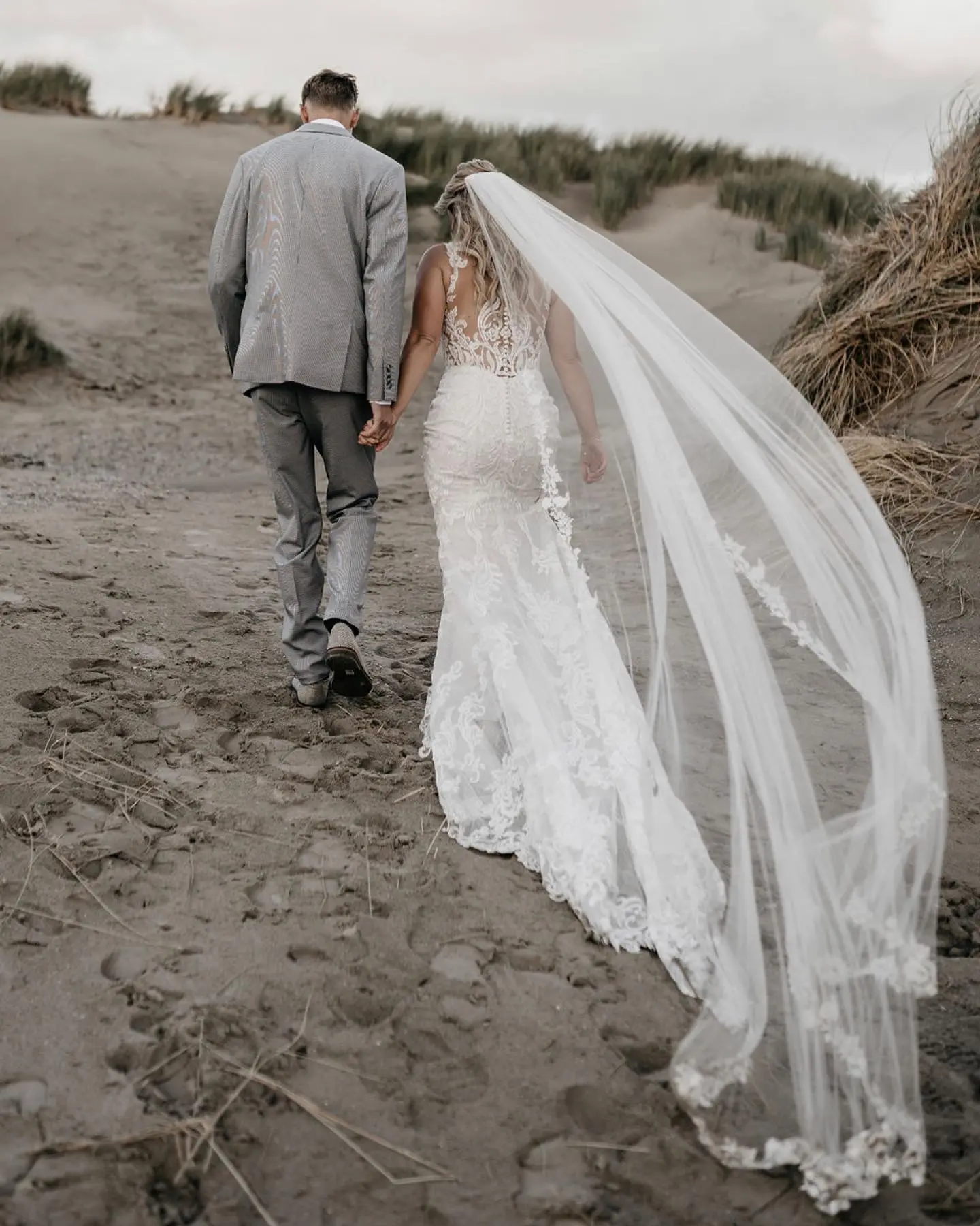 Bride Wearing Illusion Lace Back Wedding Dress Called Hamilton By Sottero And Midgley And Veil Holding Hands With Groom