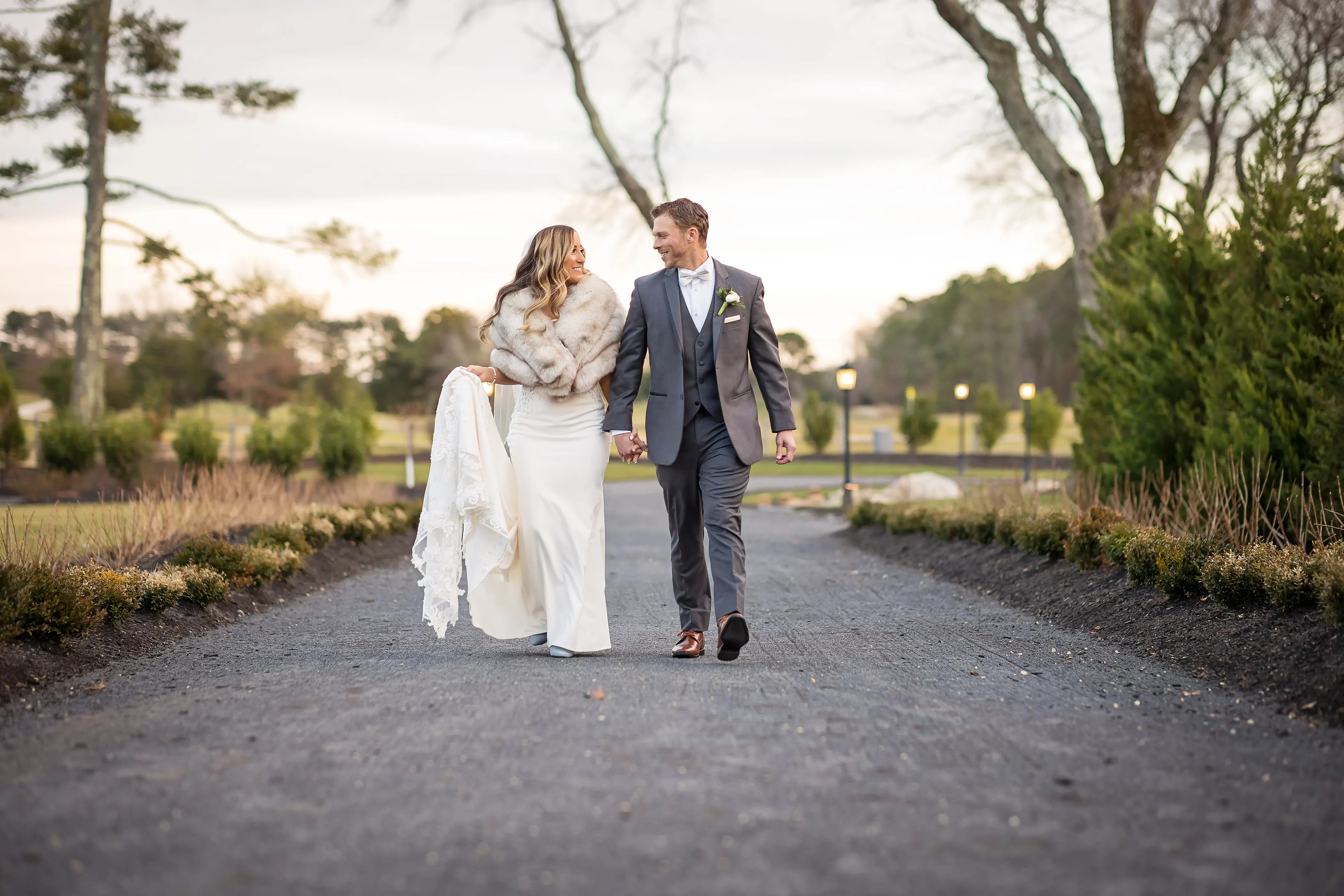 Bride Wearing Lace Mermaid Wedding Gown Called Nikki By Maggie Sottero Walking With Groom In A Vineyard