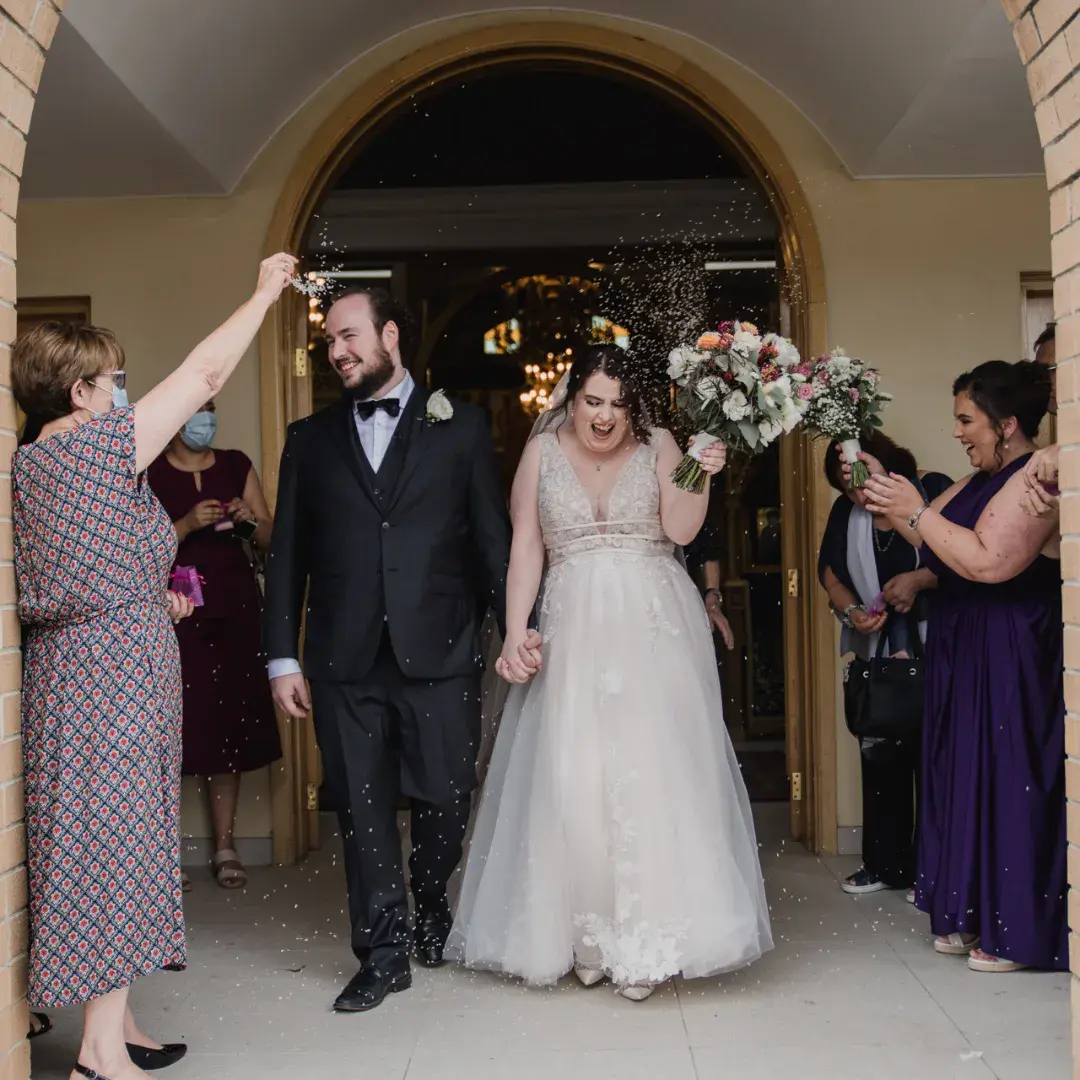 Groom After Ceremony with Bride in Plunging Illusion V-Neckline Wedding Dress Raelynn by Rebecca Ingram