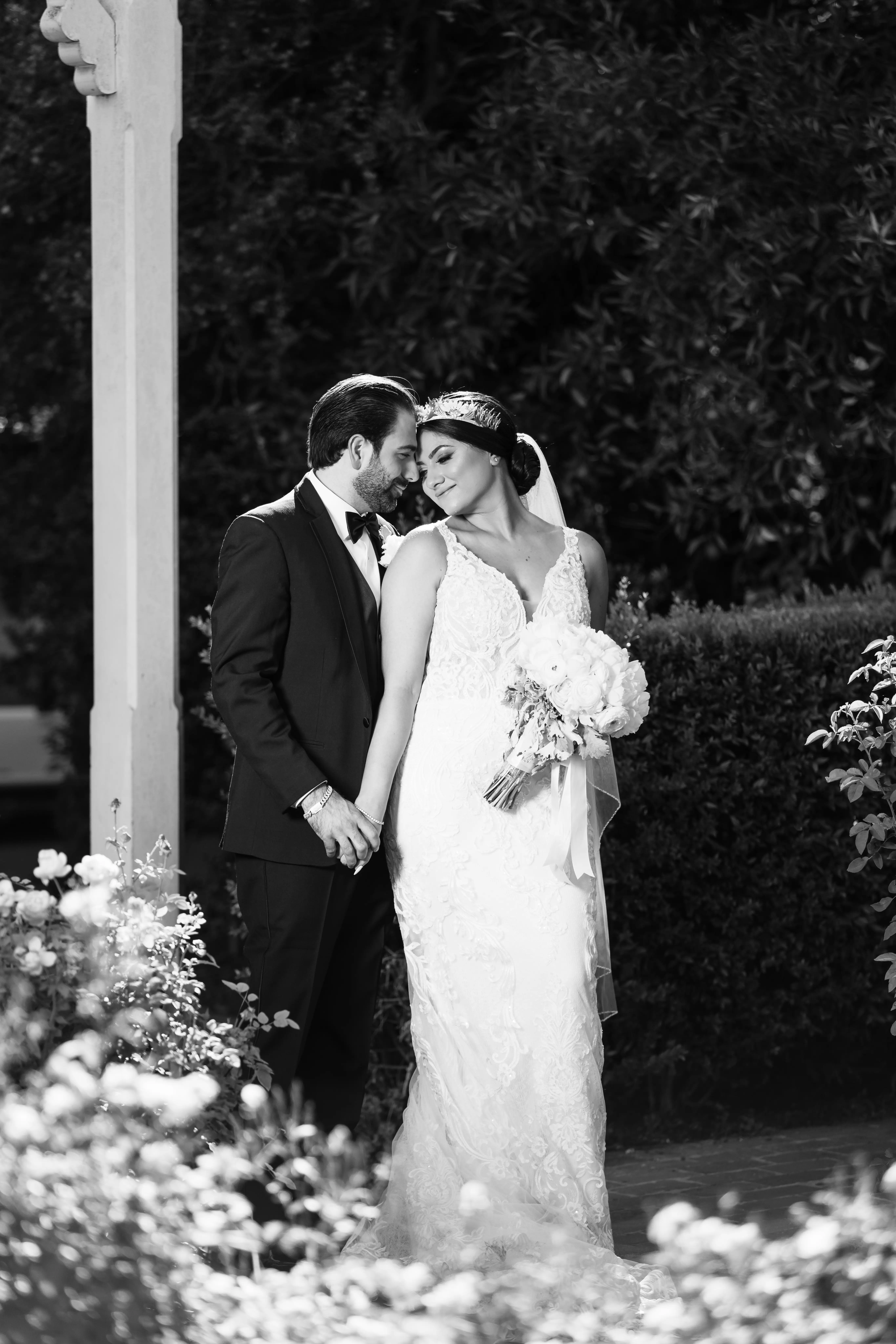 Bride Wearing Vintage Inspired Dramatic Back Wedding Dress Called Hamilton By Sottero And Midgley Posing With Groom Holding Bouquet Black And White
