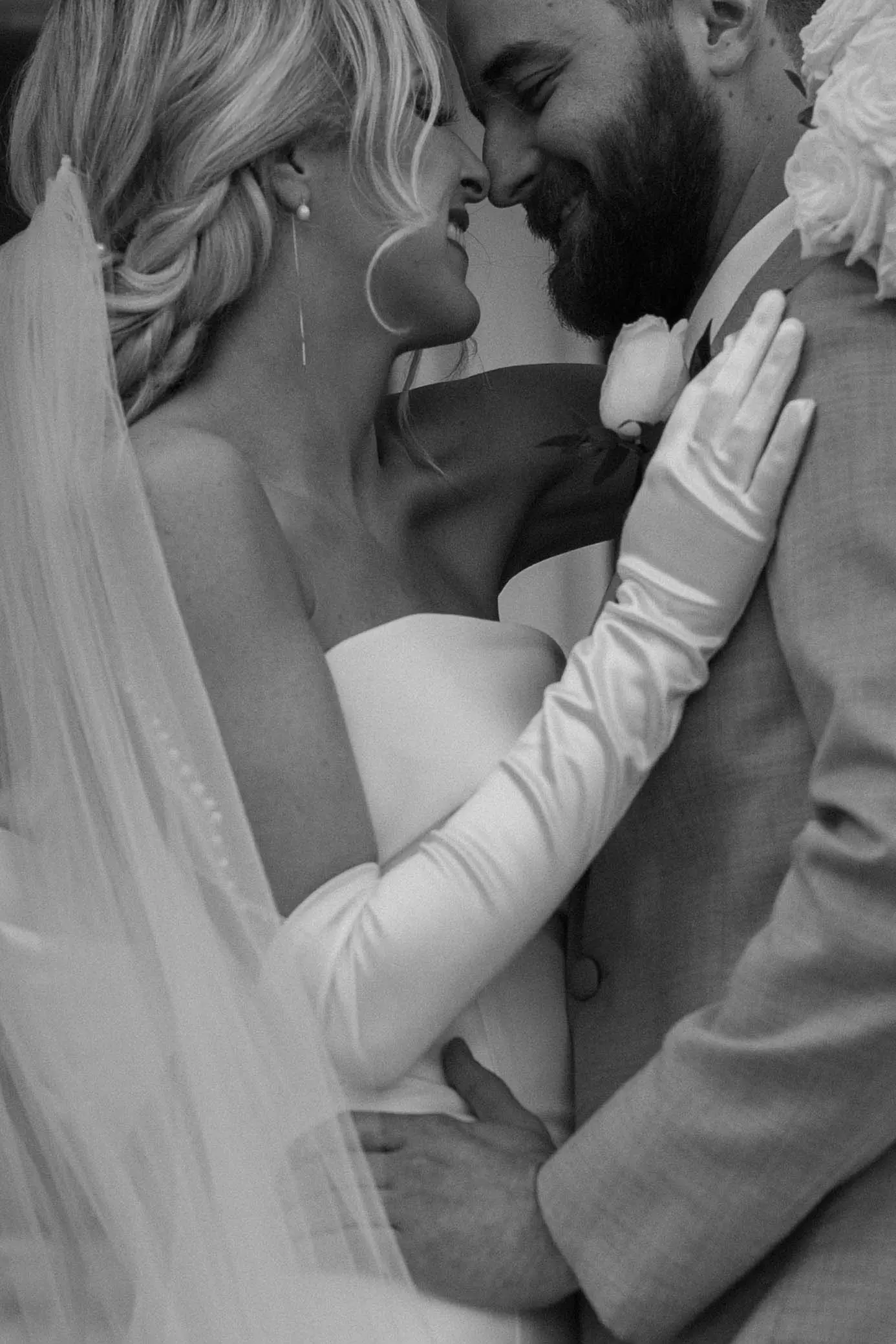 Groom Smiling With Bride In A White Strapless Wedding Dress Named Mitchell By Maggie Sottero