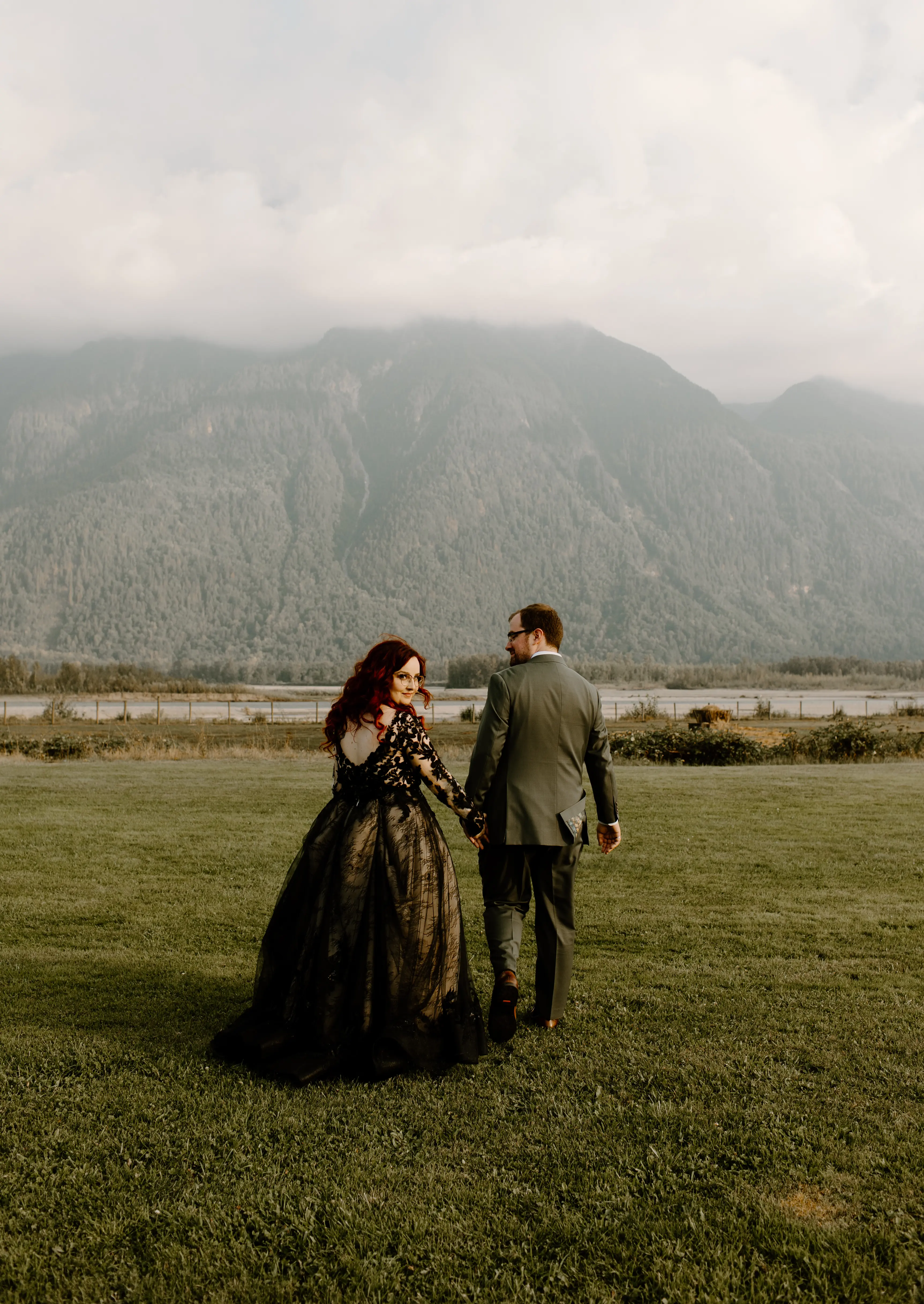 Bride Wearing Black Wedding Dress Zander By Sottero and Midgley Holding Hands With Groom And Walking Away