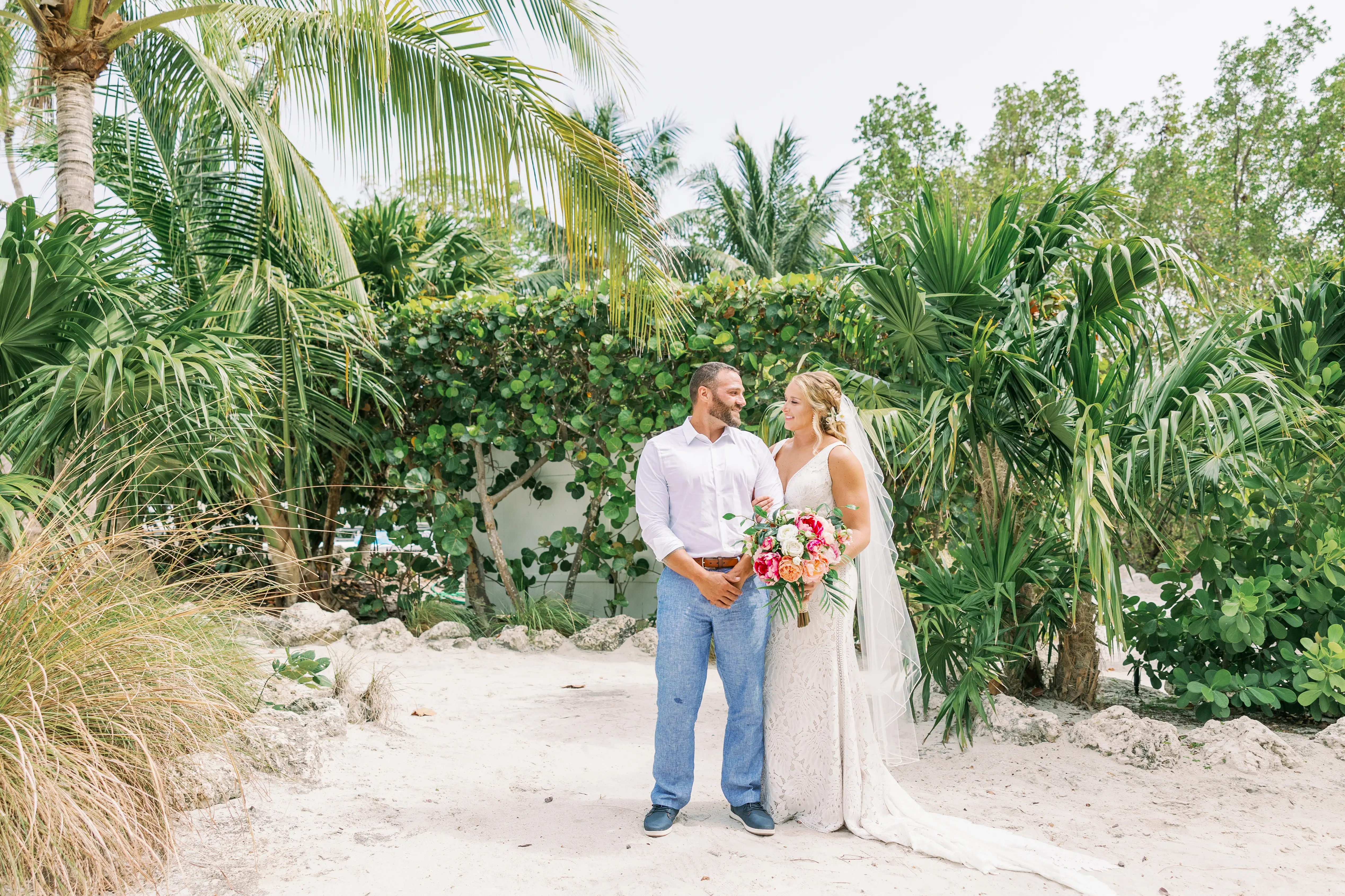 Bride and groom on the beach looking at each other.