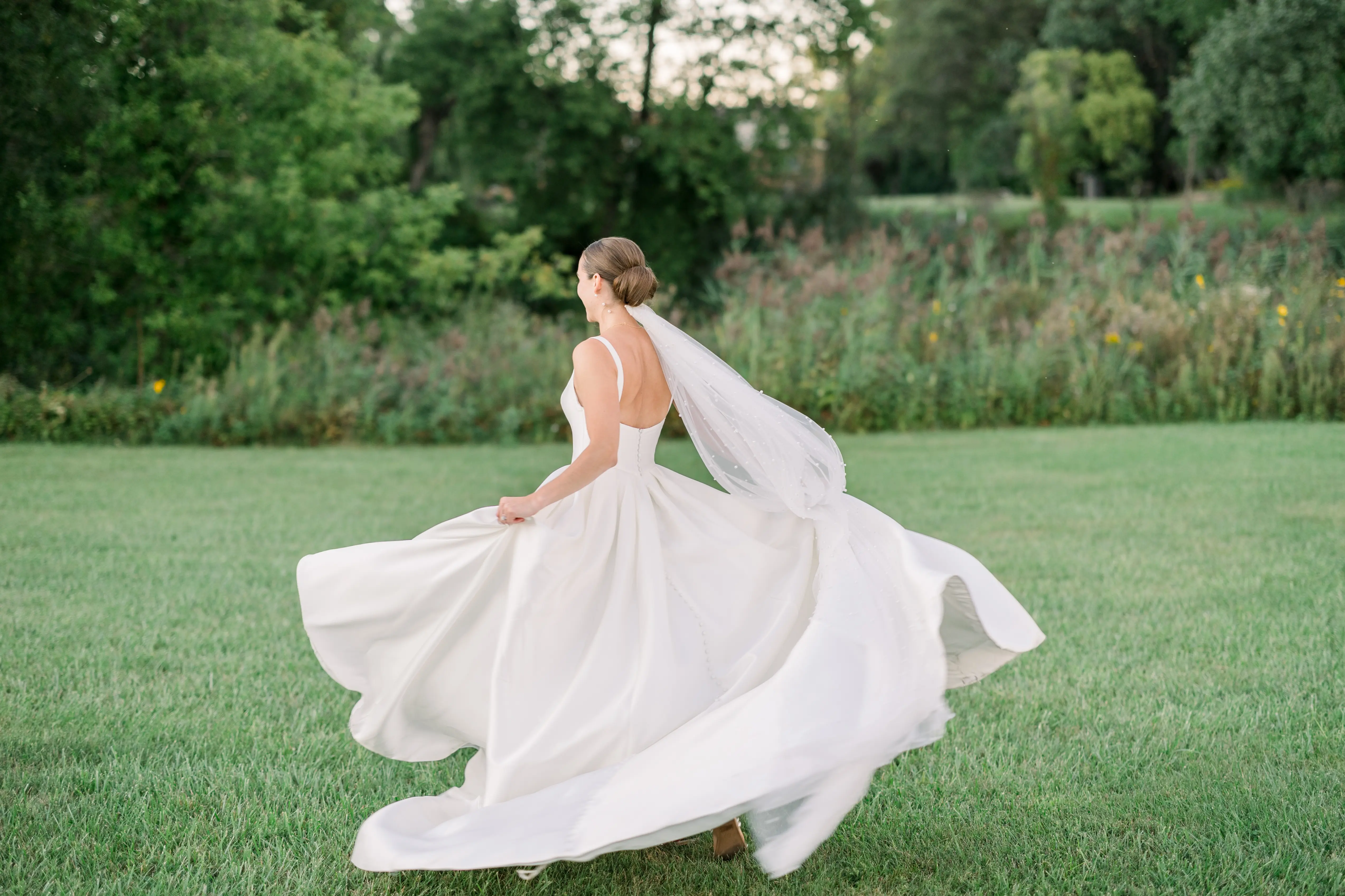 Bride Wearing Classic A-Line Wedding Dress Called Selena By Maggie Sottero Running Through A Field
