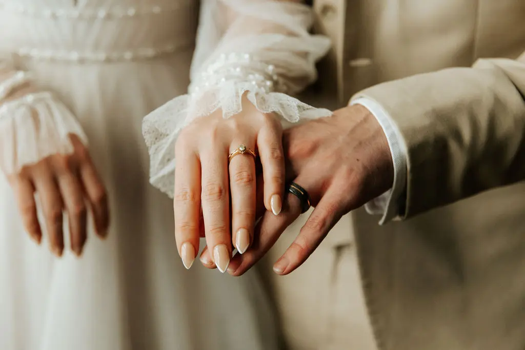 Bride Wearing Long Sleeve A-Line Wedding Dress Showing Wedding Ring with Groom