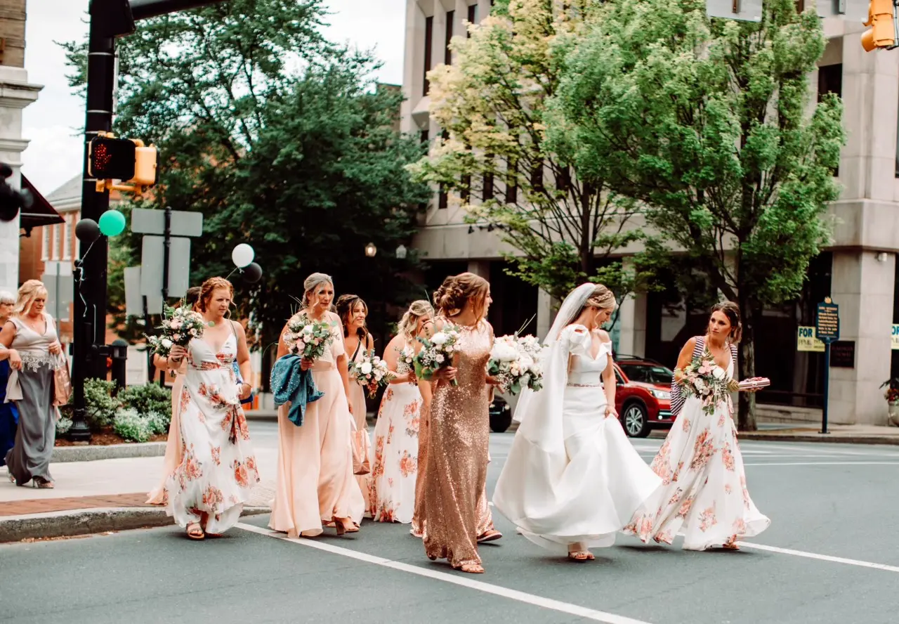Bride with her bridesmaids crossing the road in their pretty dresses.