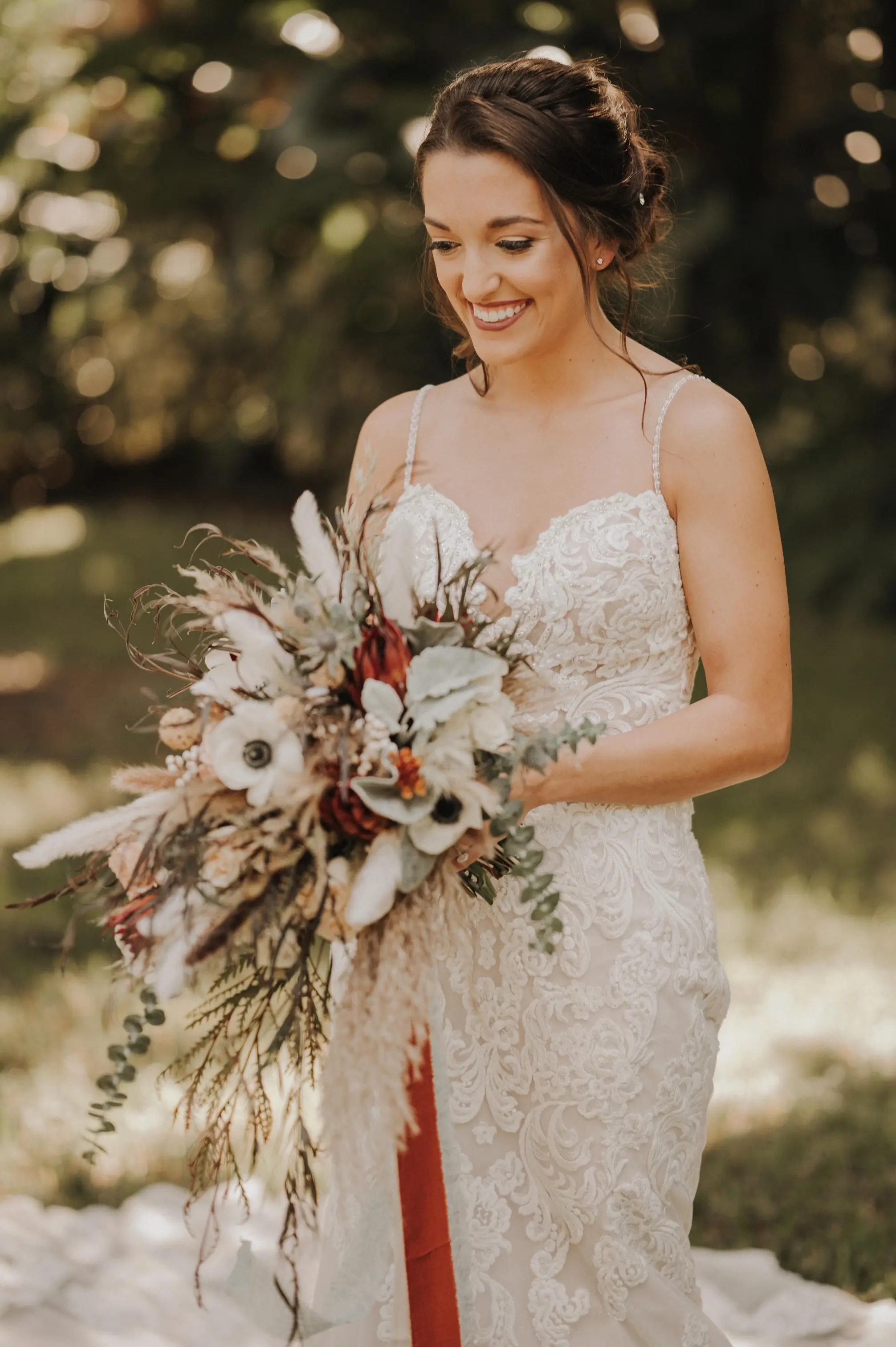 Bride holding White and Orange bouquet Wearing Lace Mermaid Wedding Gown Called Fiona by Maggie Sottero