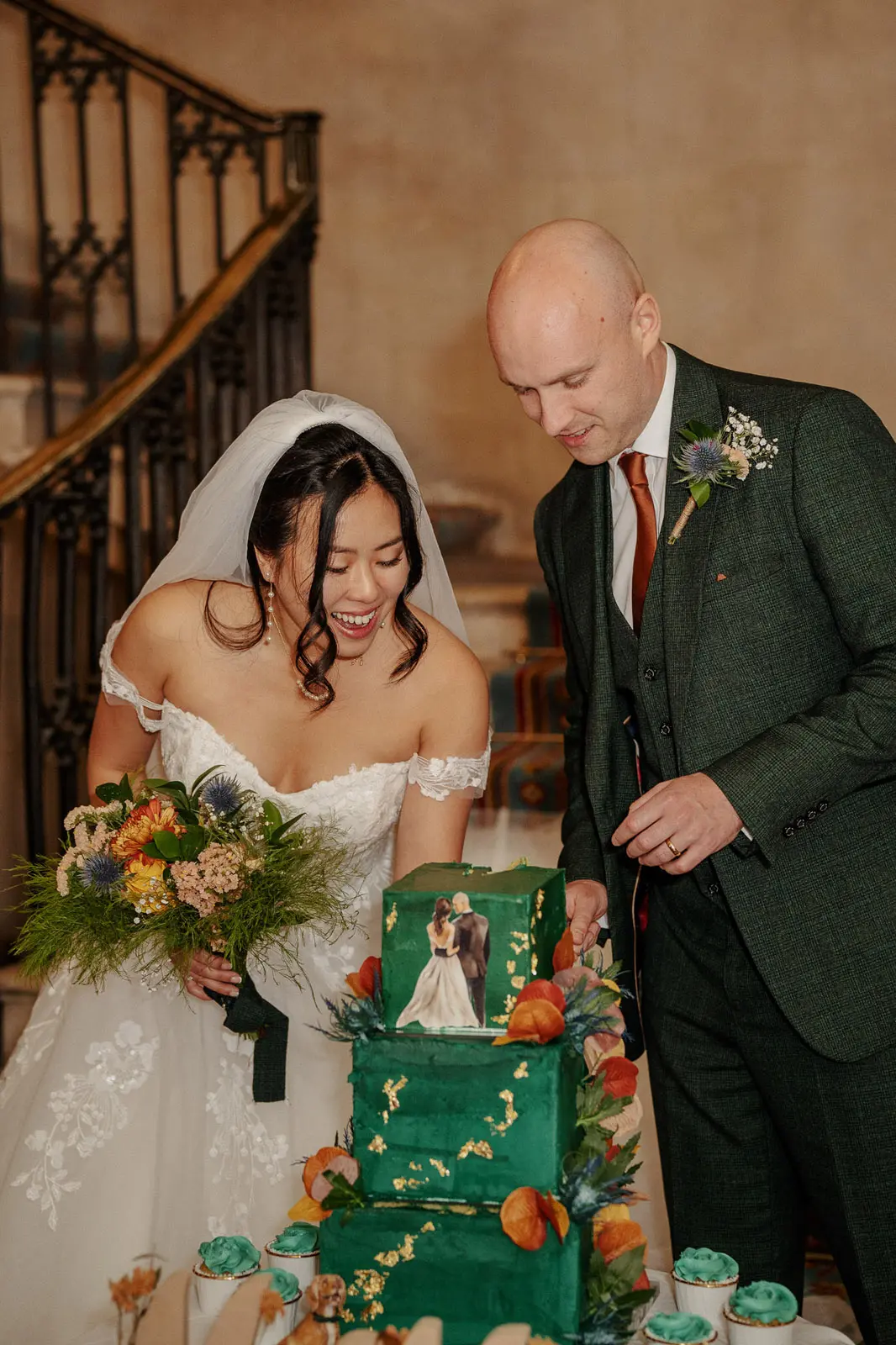 Bride wearing Harlem by Maggie Sottero and her husband cutting the cake