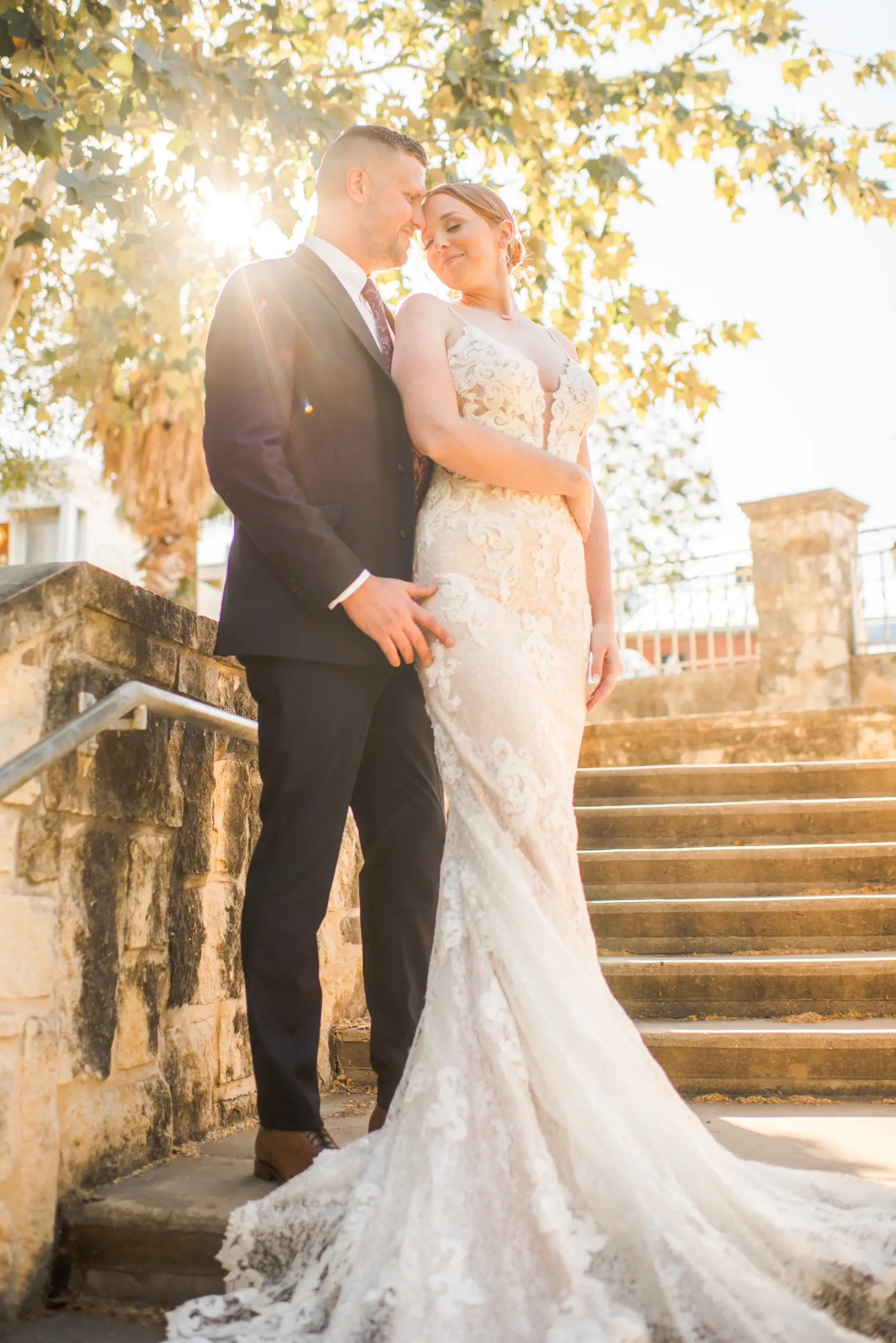 Bride Wearing Glamorous Lace And Sequin Wedding Dress Called Tuscany By Maggie Sottero Posing With Groom In Sunlight