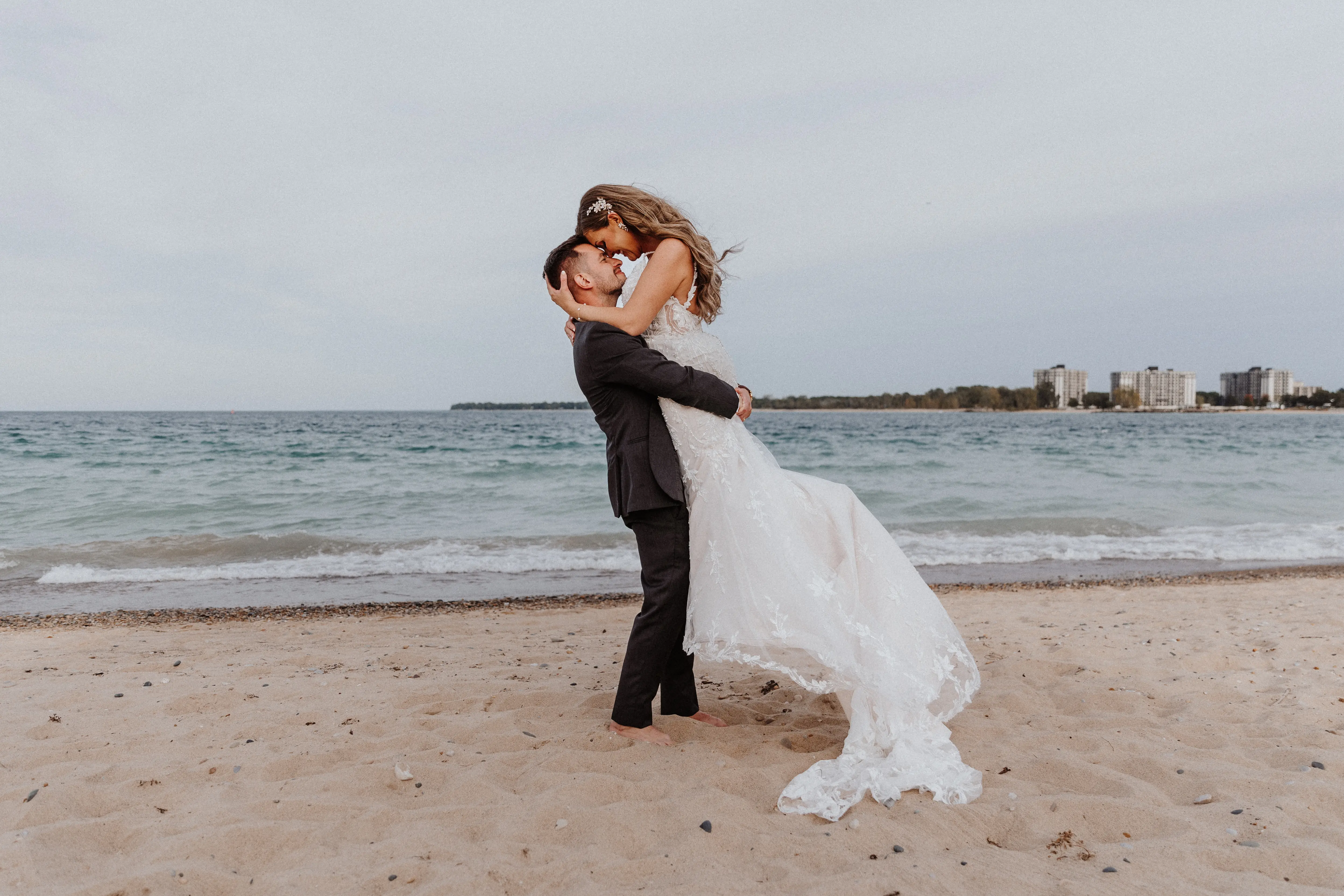 Bride Wearing Beaded Fit-n-flare Wedding Dress Called Jonah Lane By Sottero And Midgley With Groom On The Beach