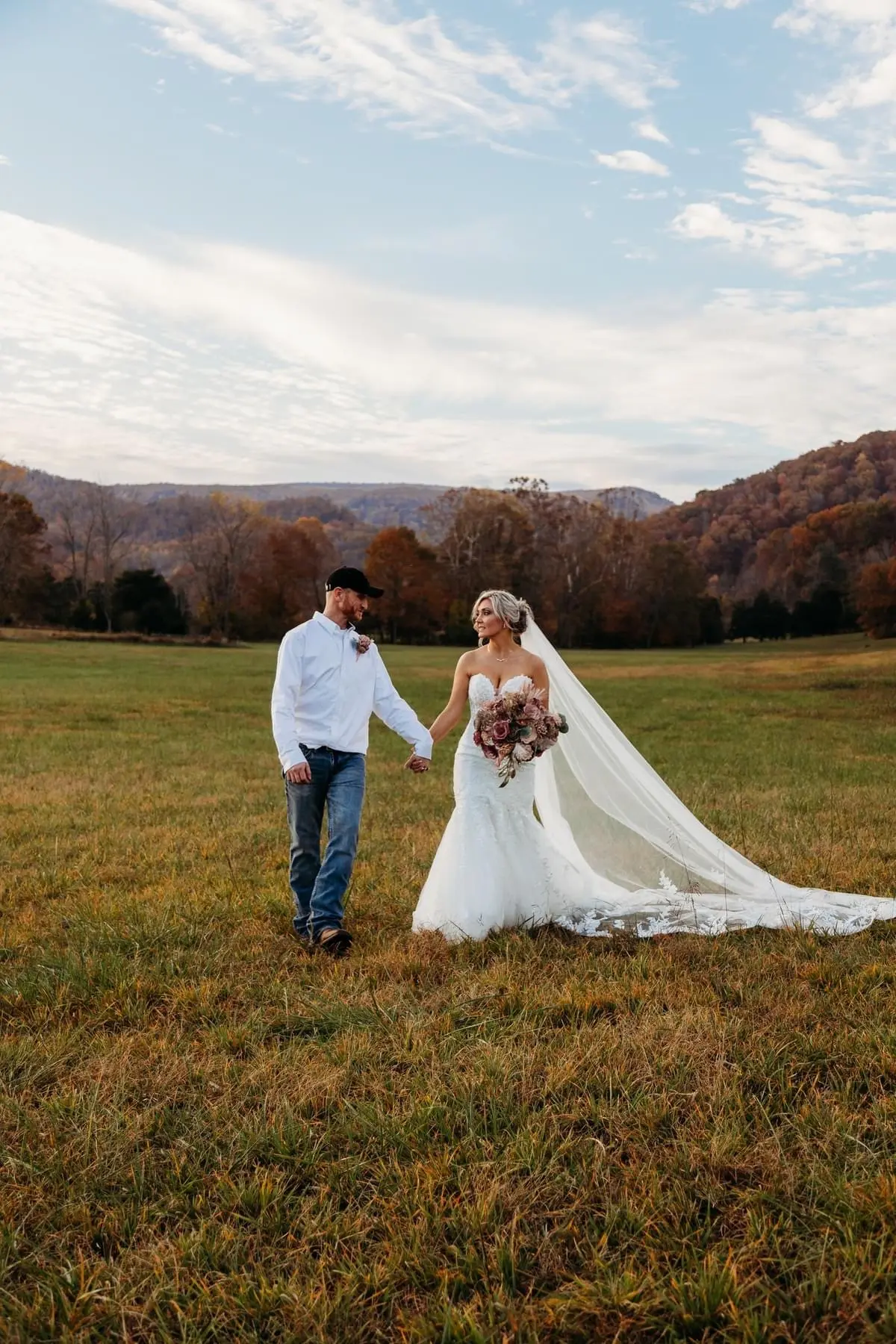 Bride wearing Lennon wedding dress by Maggie Sottero holding hands with her husband