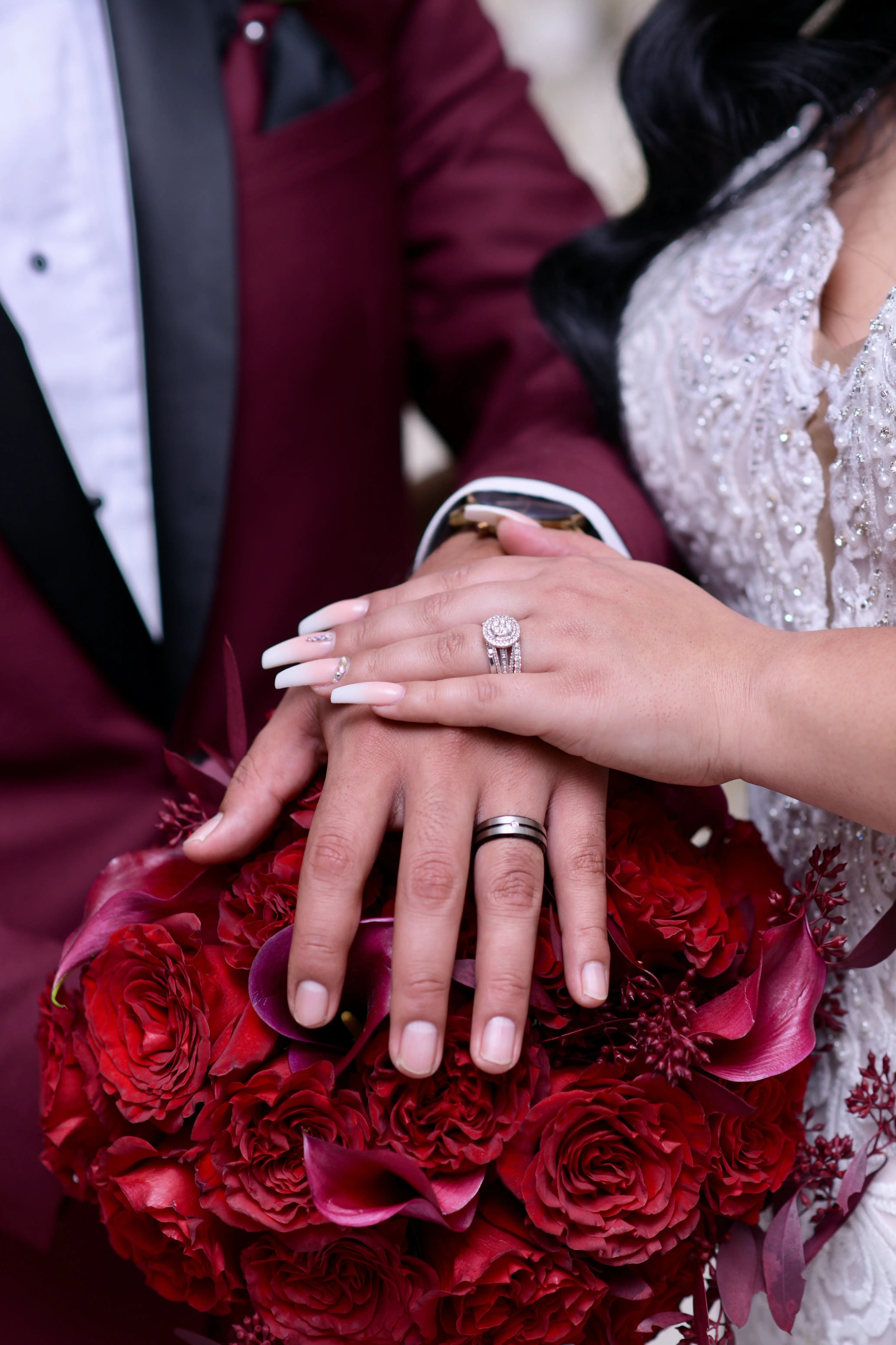 Newlyweds hands on top of each other showing off their sparkly rings.