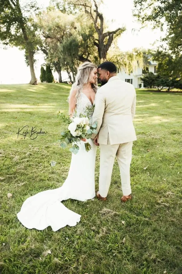 Bride with groom wearing sexy v back sheath wedding dress