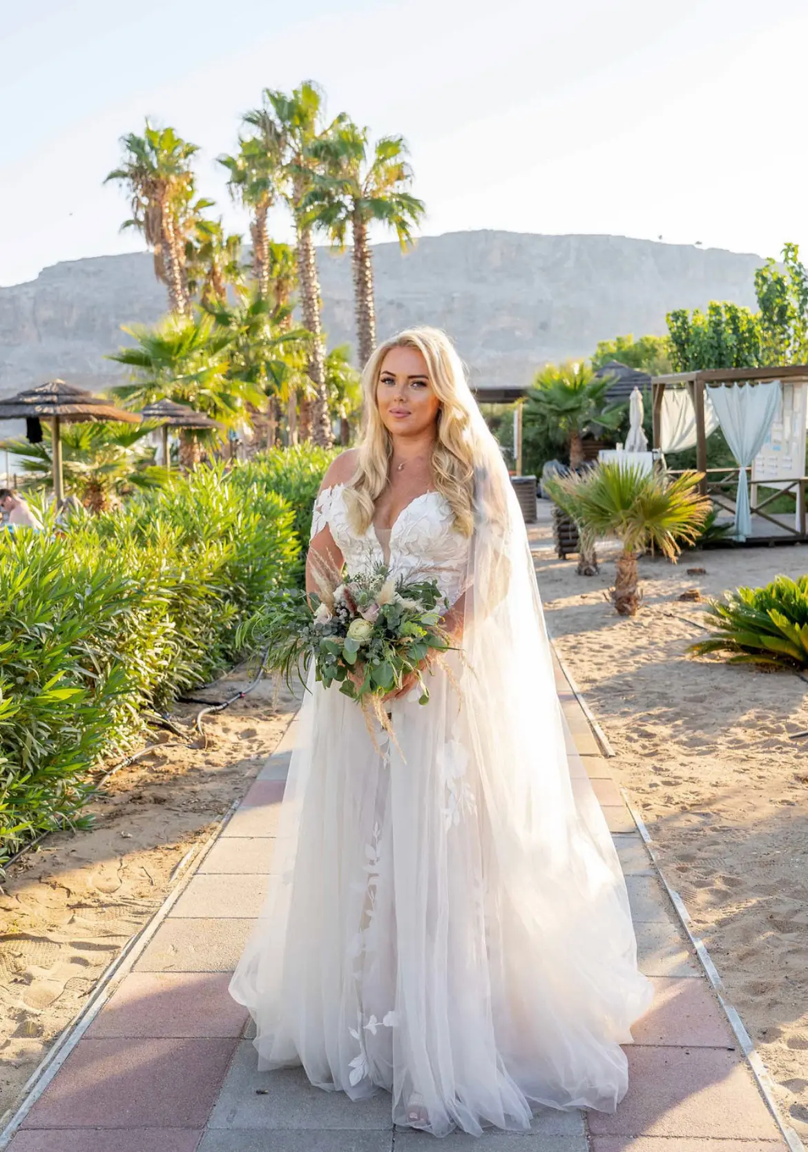 Bride with Bouquet at Greece Wedding Wearing Sexy Boho Wedding Gown Called Hattie Lane Marie by Rebecca Ingram.