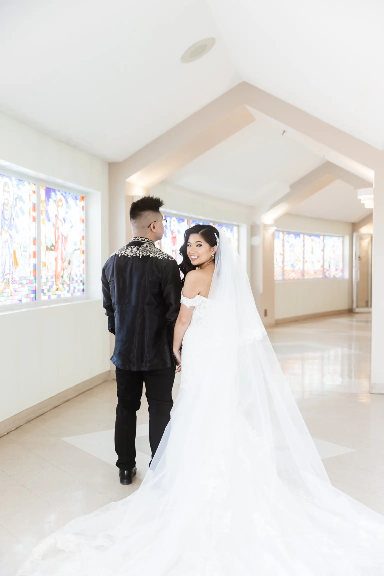 Bride wearing Fiona by Maggie Sottero holding hands with her husband