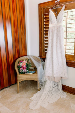 Dress called Burke hanging by window with wooden shutter blinds.