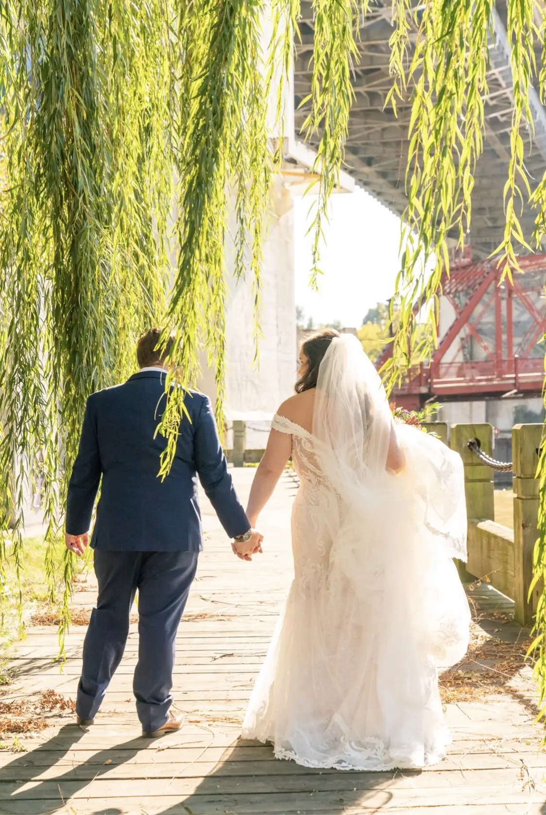 Bride with groom wearing cap sleeve lace mermaid wedding dress.