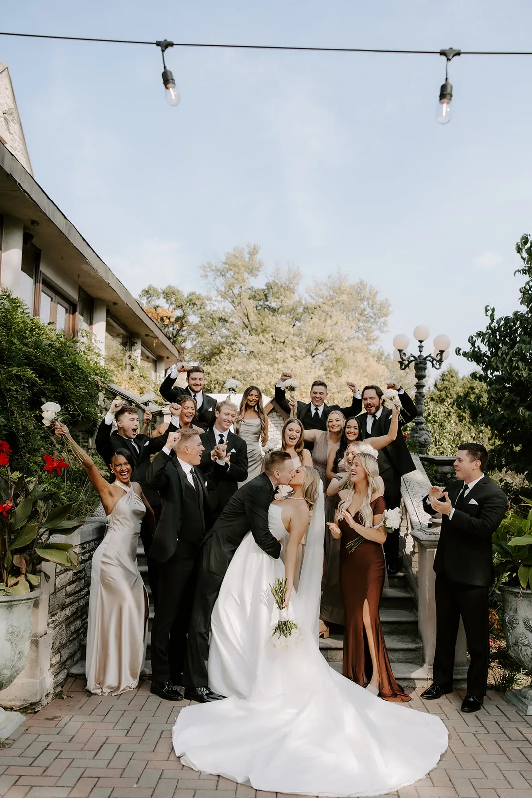 Bride Wearing Simple Aline Wedding Dress Called Aspen By Sottero And Midgley Kissing Groom With Bridal Party Cheering
