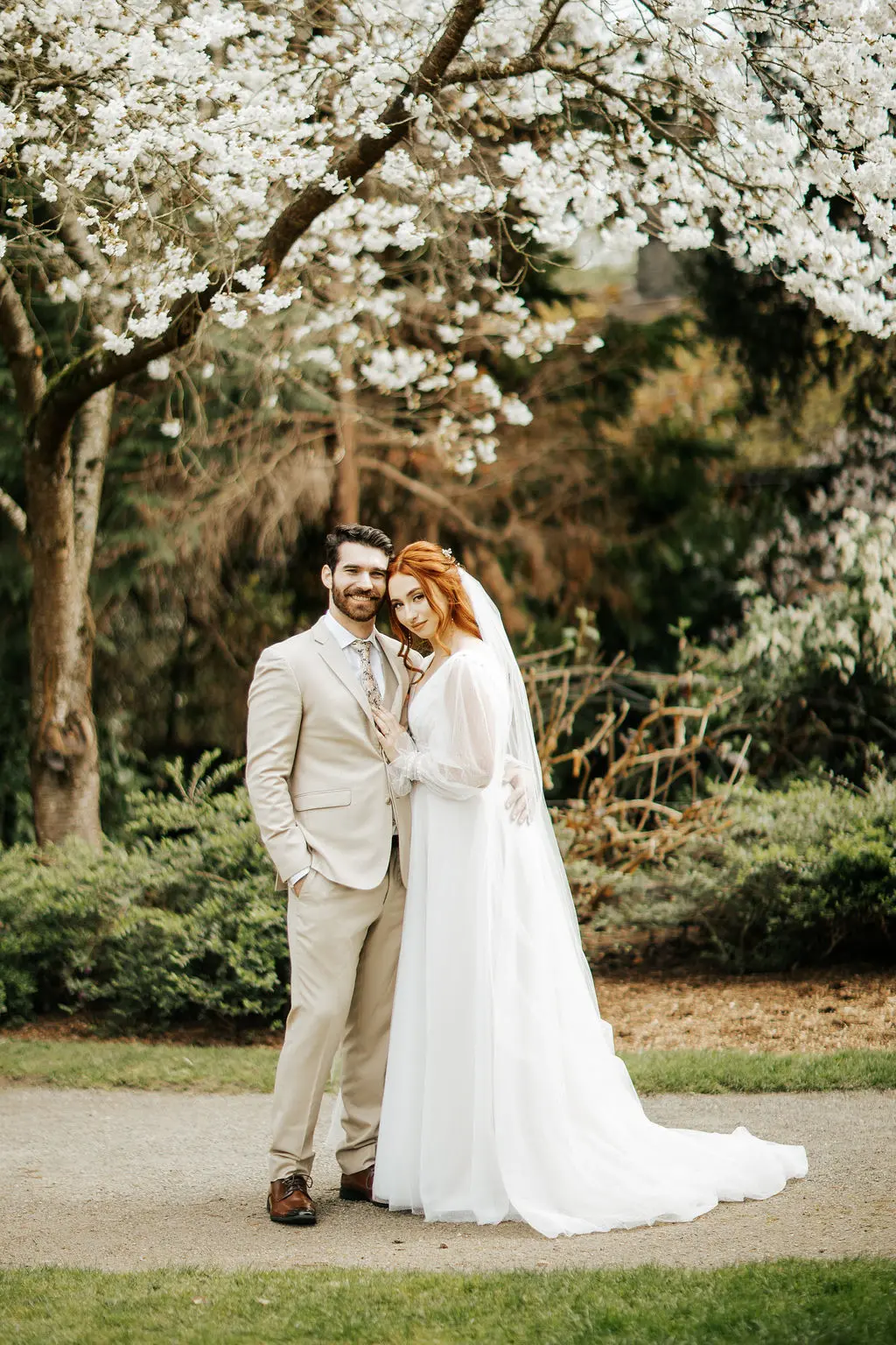 Bride Wearing Long Sleeve Sparkly A-Line Wedding Dress with Groom Outdoors.